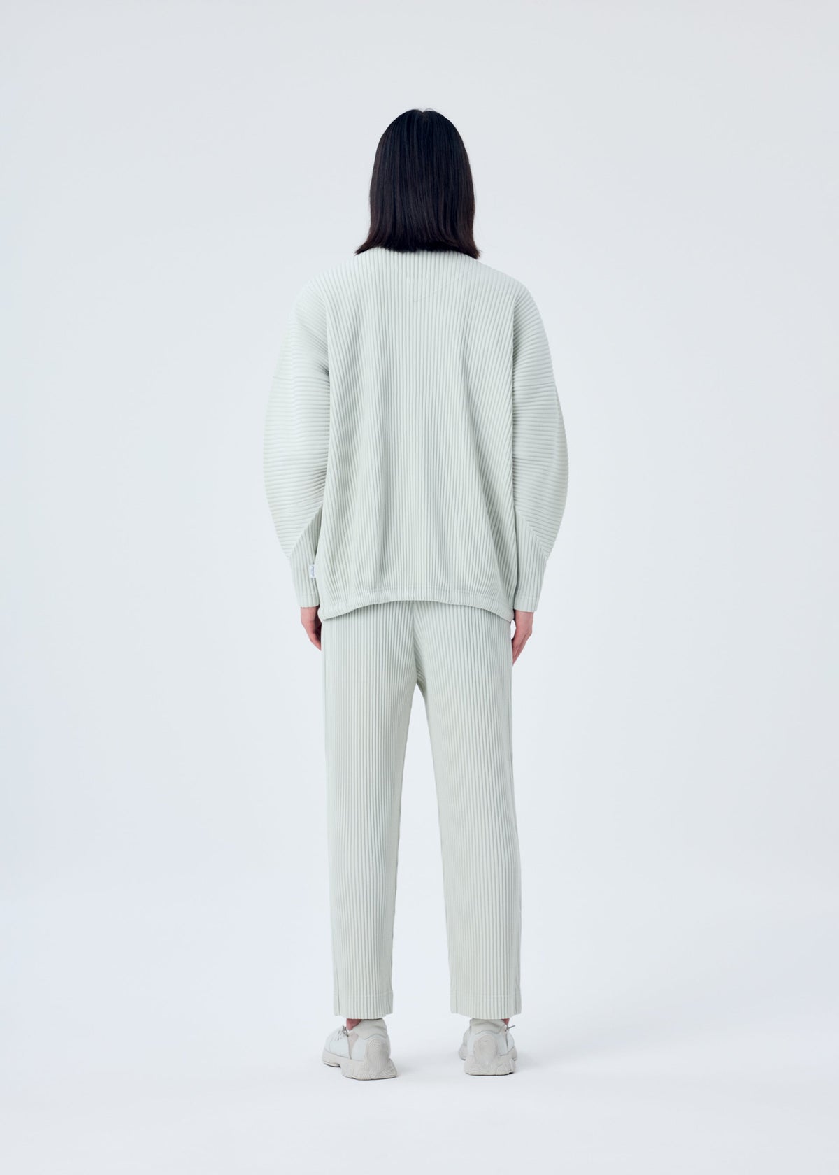 A model wears the HOMME PLISSÉ ISSEY MIYAKE MC MARCH jacket.