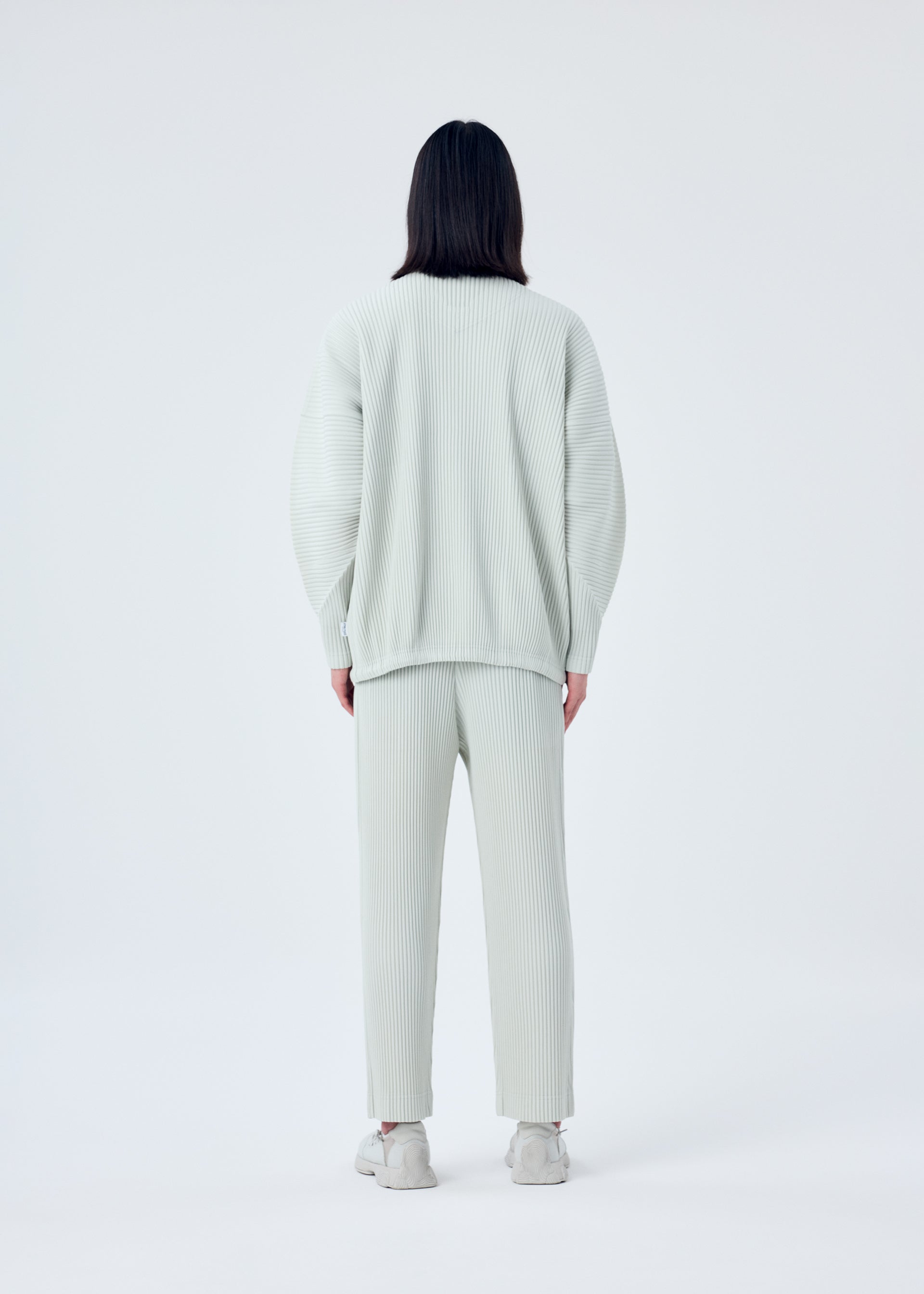 A model wears the HOMME PLISSÉ ISSEY MIYAKE MC MARCH jacket.
