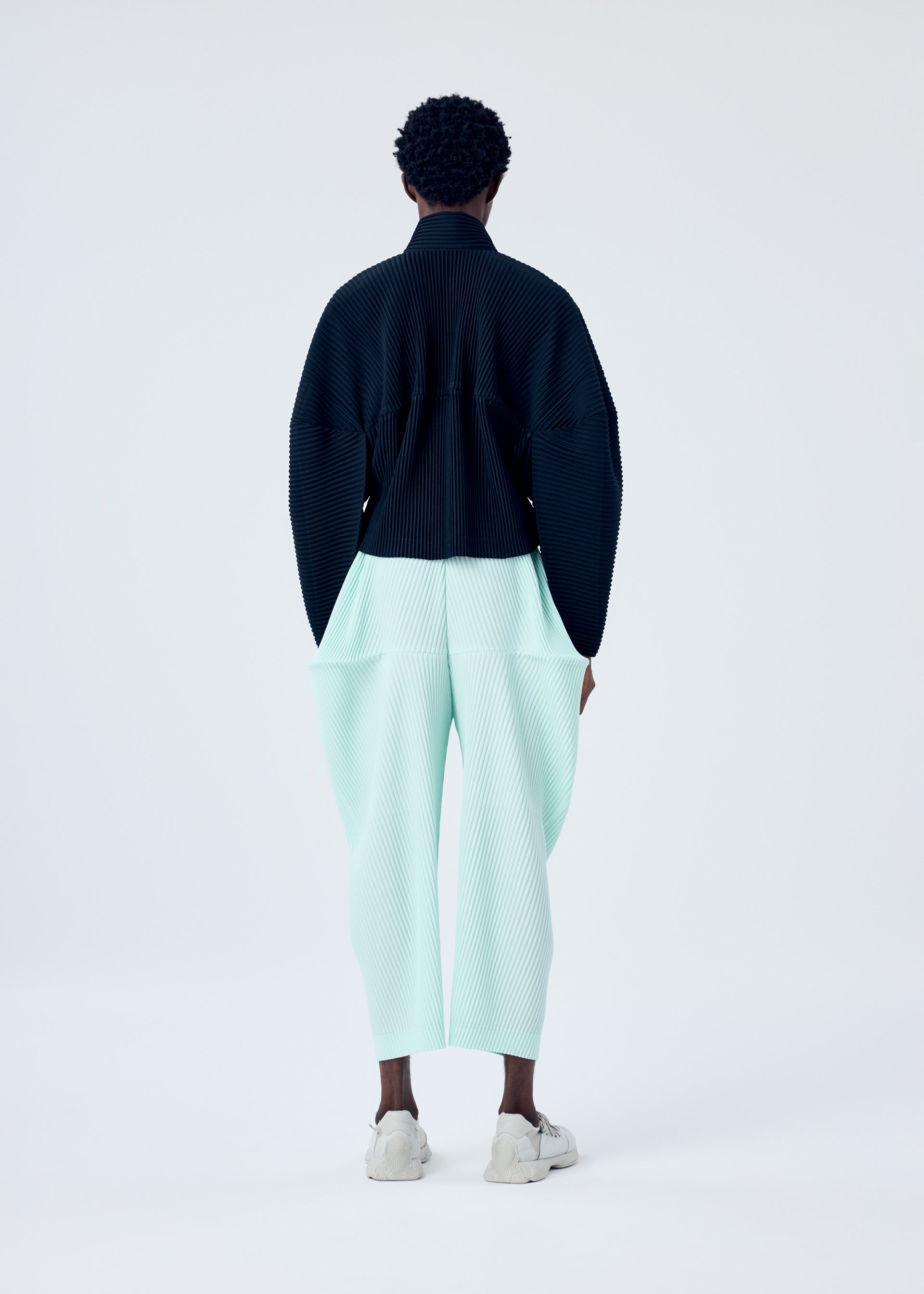 A model wears the HOMME PLISSÉ ISSEY MIYAKE KINETIC SCULPTURE jacket.