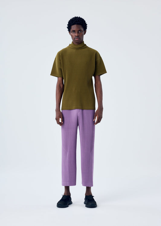 A model wears the HOMME PLISSÉ ISSEY MIYAKE MC APRIL trousers.