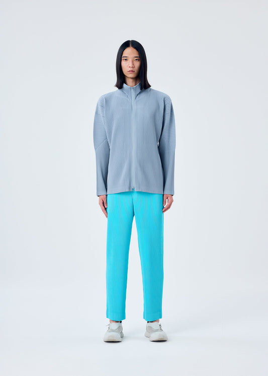 A model wears the HOMME PLISSÉ ISSEY MIYAKE COLOR PLEATS trousers.