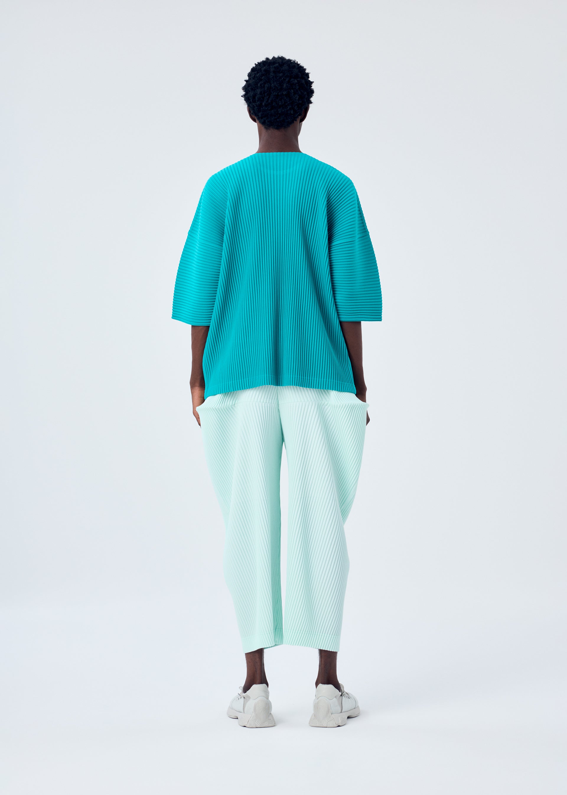 A model wears the HOMME PLISSÉ ISSEY MIYAKE KINETIC SCULPTURE trousers.