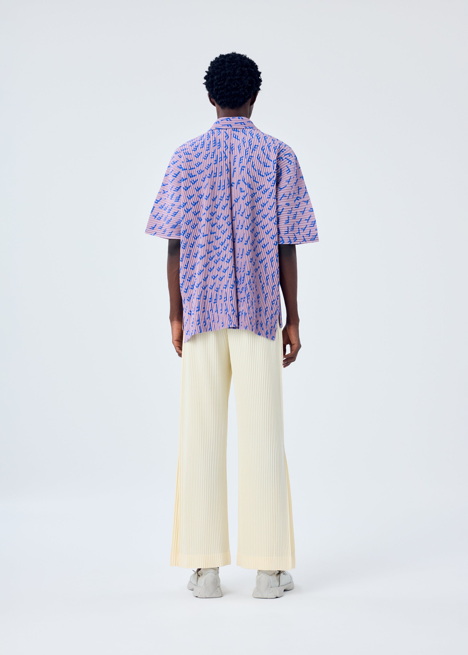 A model wears the HOMME PLISSÉ ISSEY MIYAKE WIND SPEED shirt.