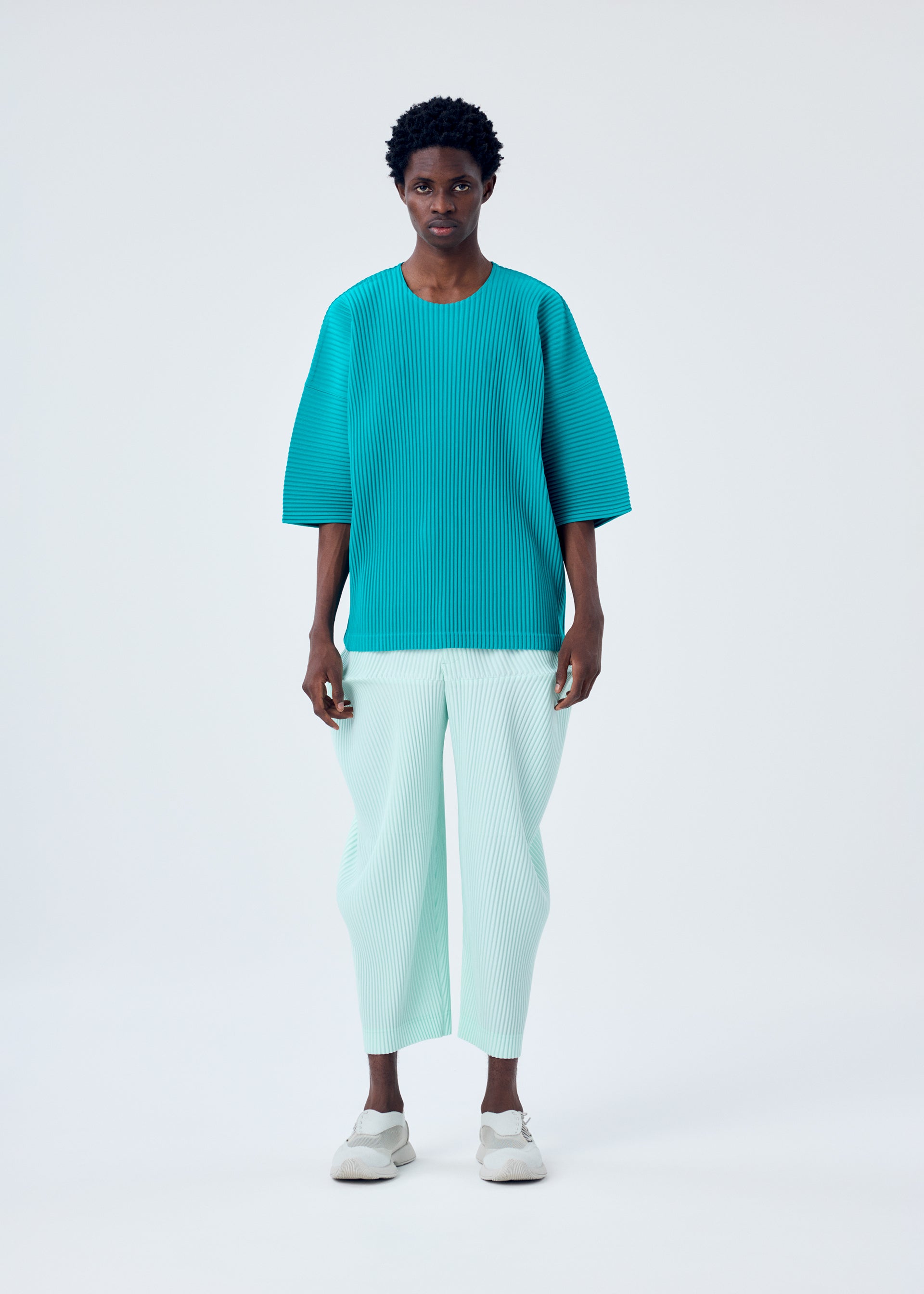 A model wears the HOMME PLISSÉ ISSEY MIYAKE MC MAY top.