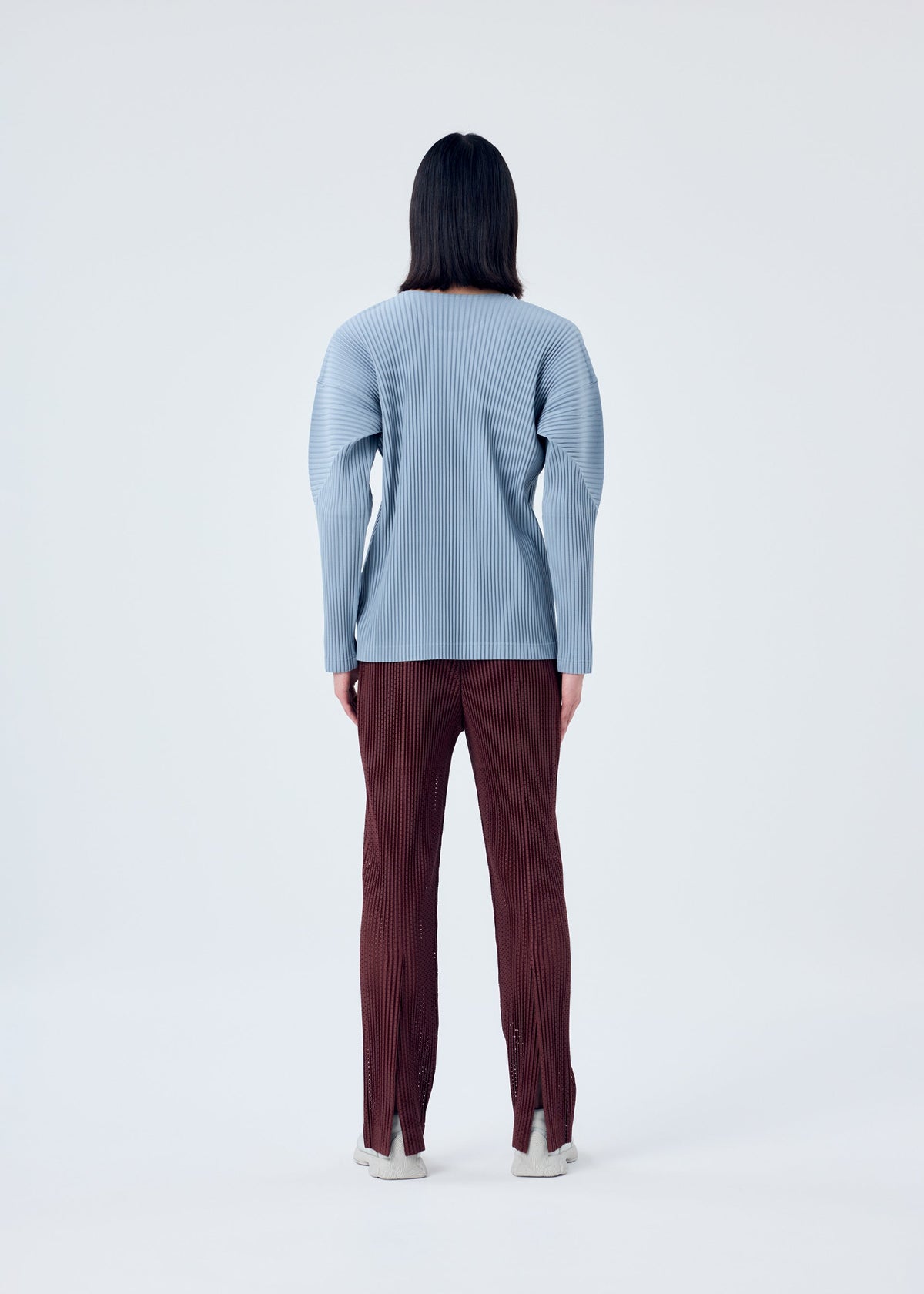 A model wears the HOMME PLISSÉ ISSEY MIYAKE COLOR PLEATS top.