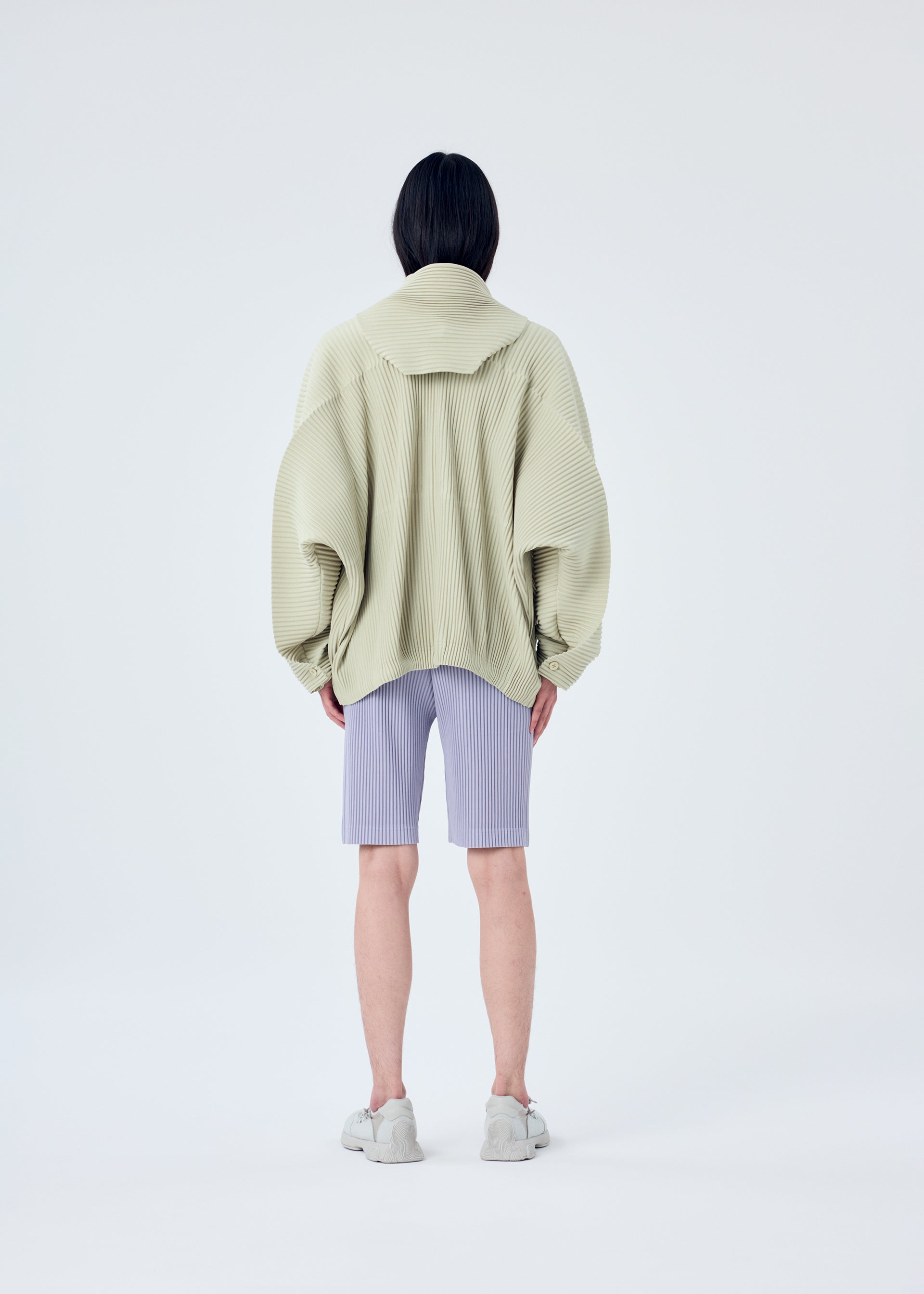 A model wears the HOMME PLISSÉ ISSEY MIYAKE MC MAY shirt.