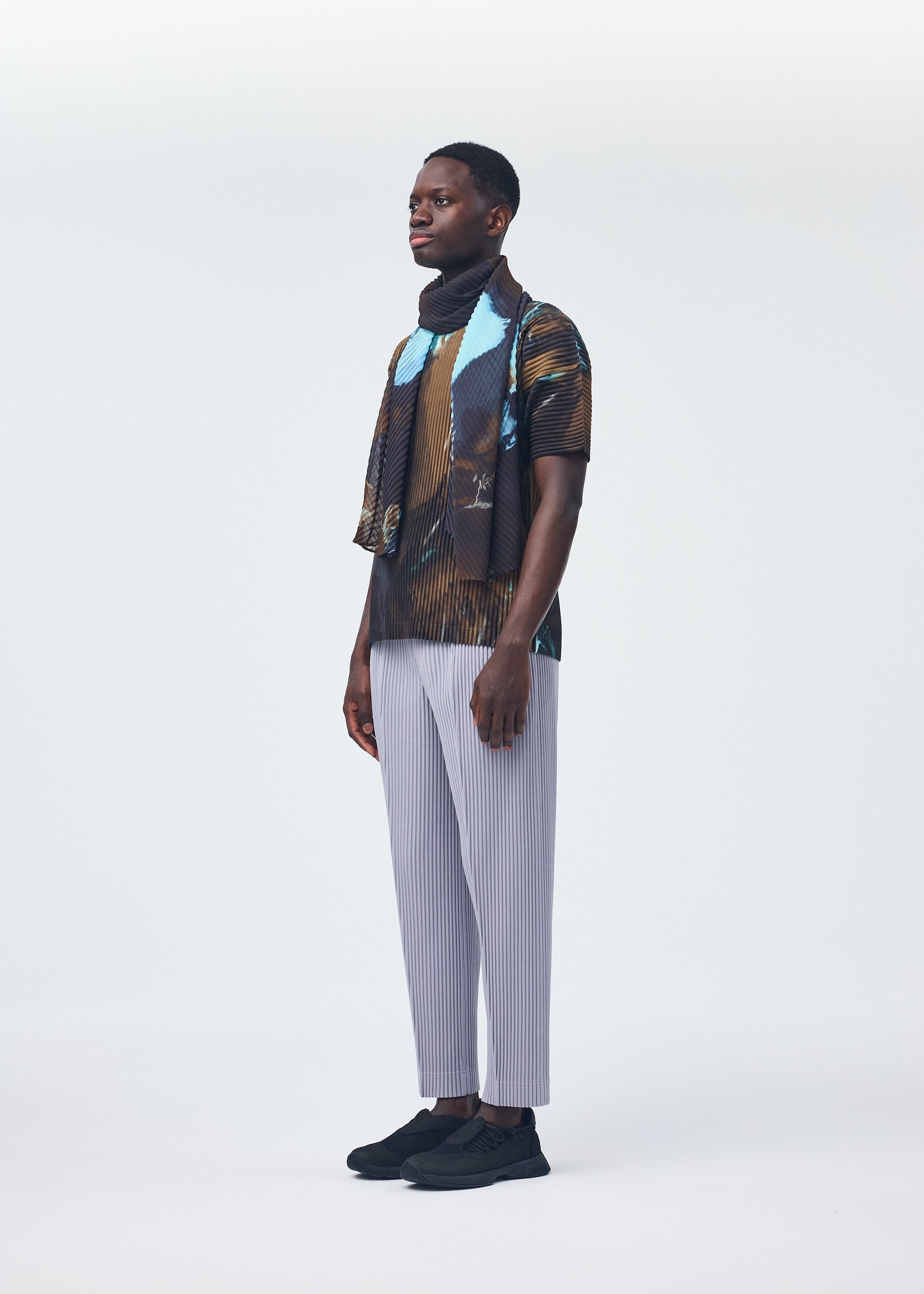 A model wears the HOMME PLISSÉ ISSEY MIYAKE AGATE SCARF stole.