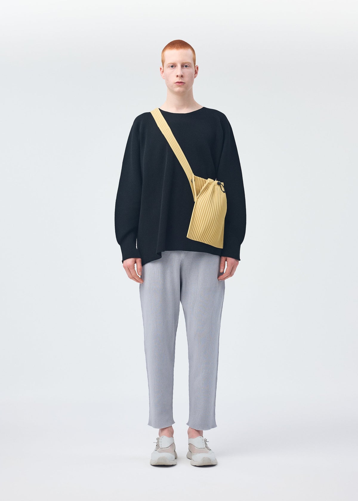 A model wears the HOMME PLISSÉ ISSEY MIYAKE POCKET bag.