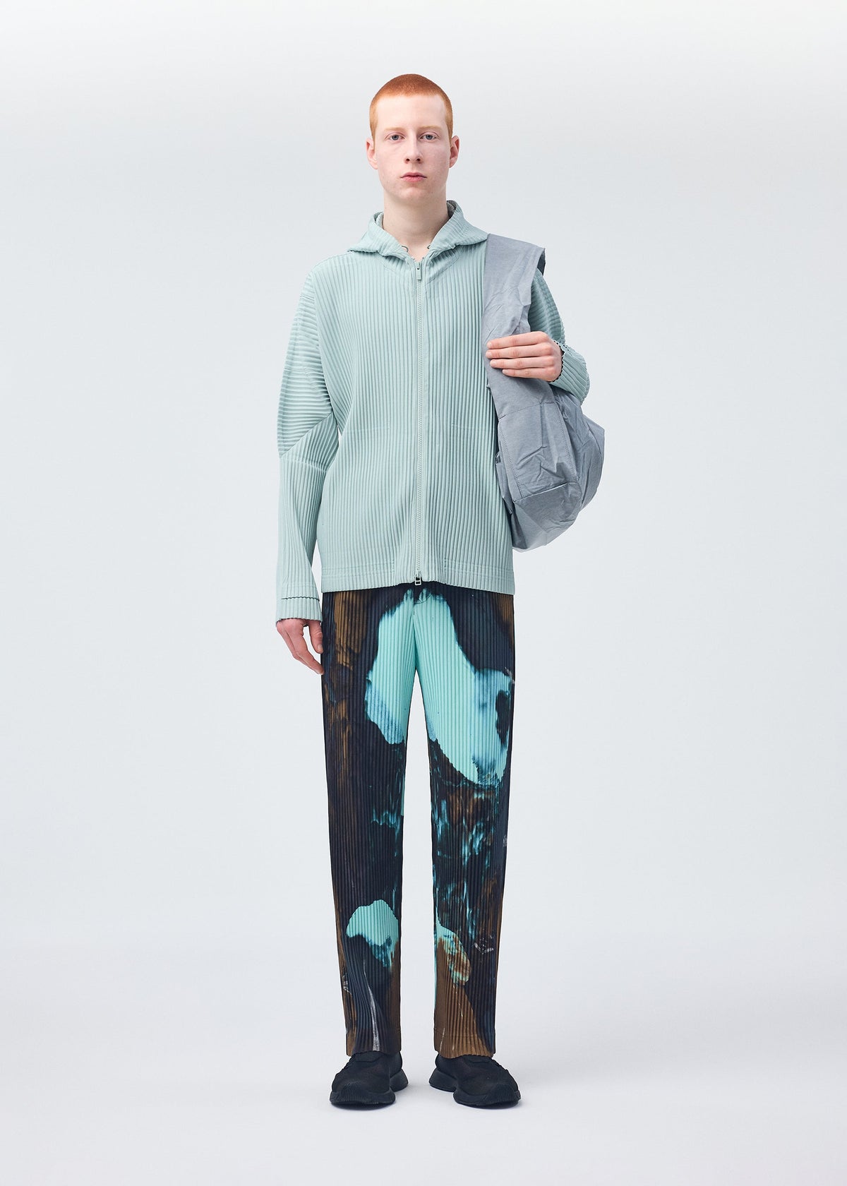 A model wears the HOMME PLISSÉ ISSEY MIYAKE STONE BAG bag.