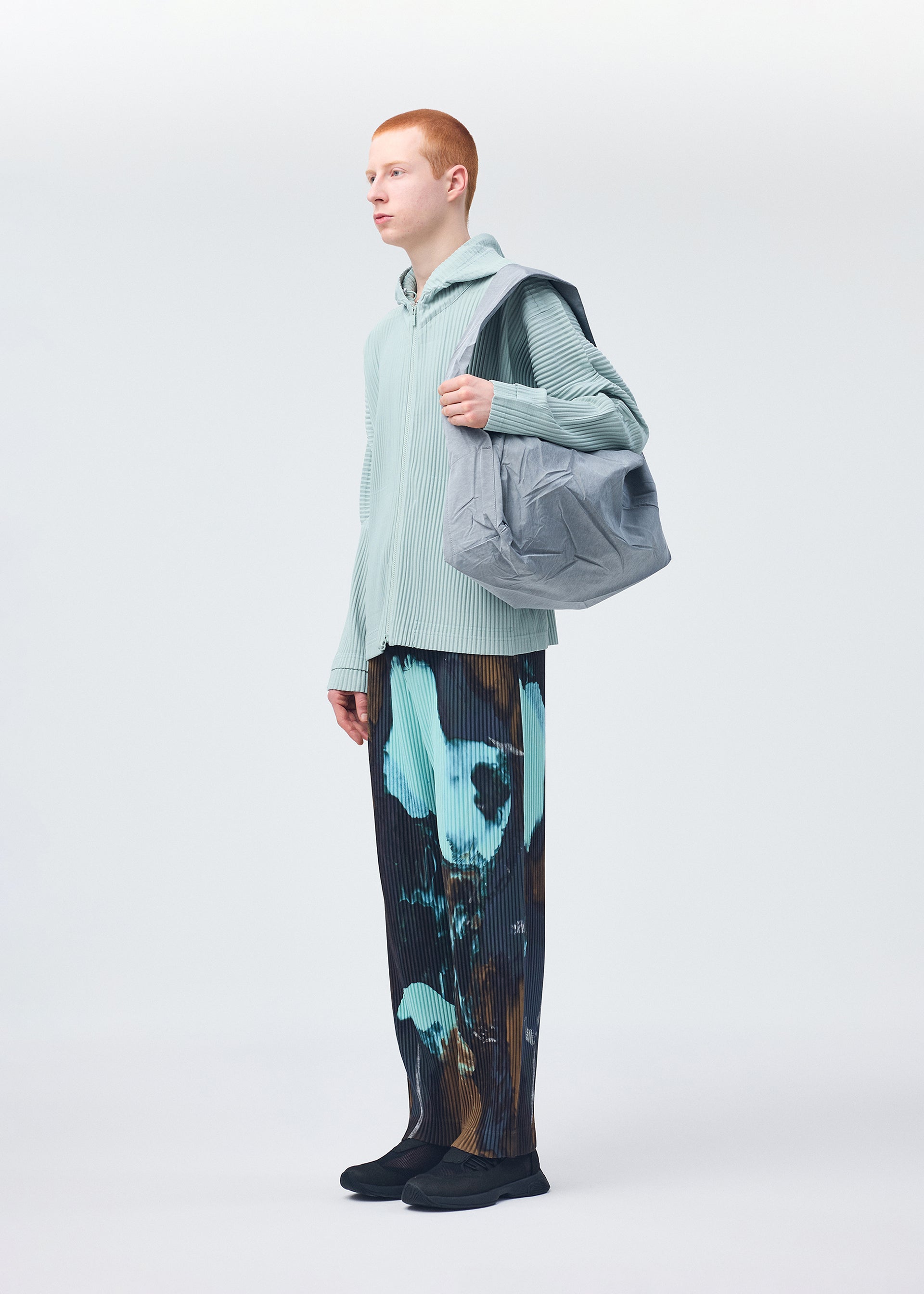 A model wears the HOMME PLISSÉ ISSEY MIYAKE STONE BAG bag.