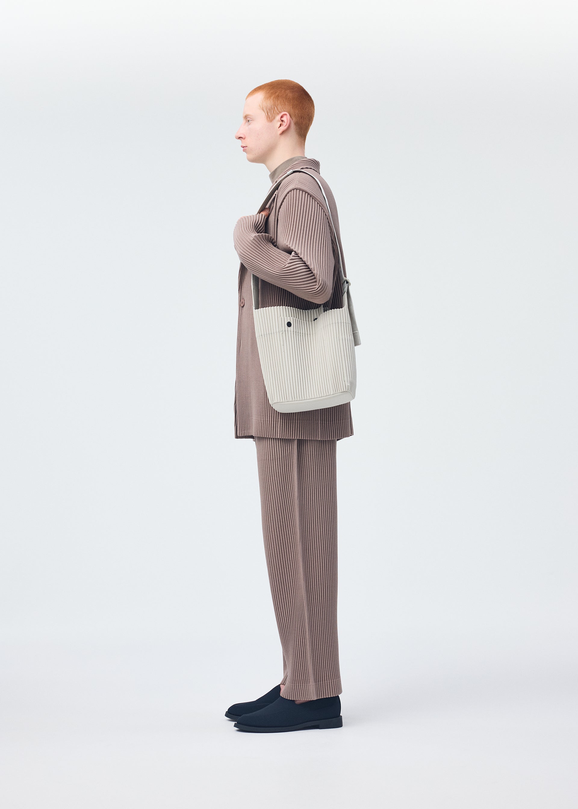 A model wears the HOMME PLISSÉ ISSEY MIYAKE UTILITY bag.