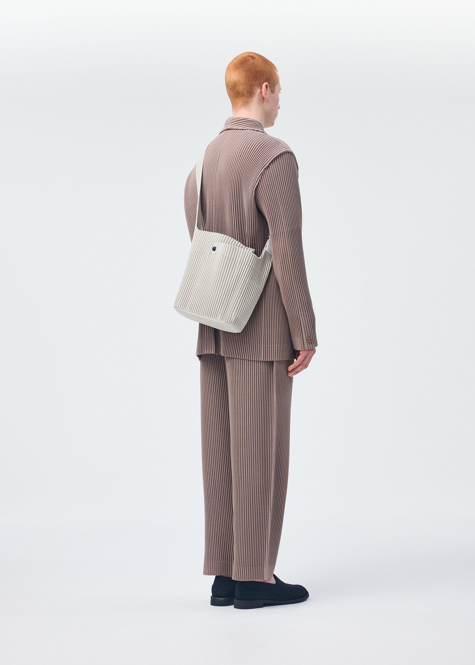 A model wears the HOMME PLISSÉ ISSEY MIYAKE UTILITY bag.