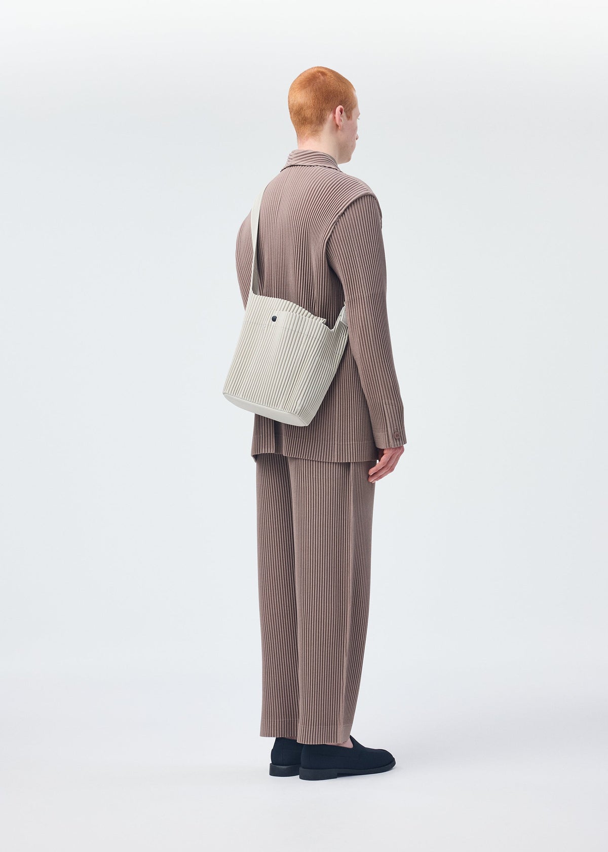 A model wears the HOMME PLISSÉ ISSEY MIYAKE UTILITY bag.