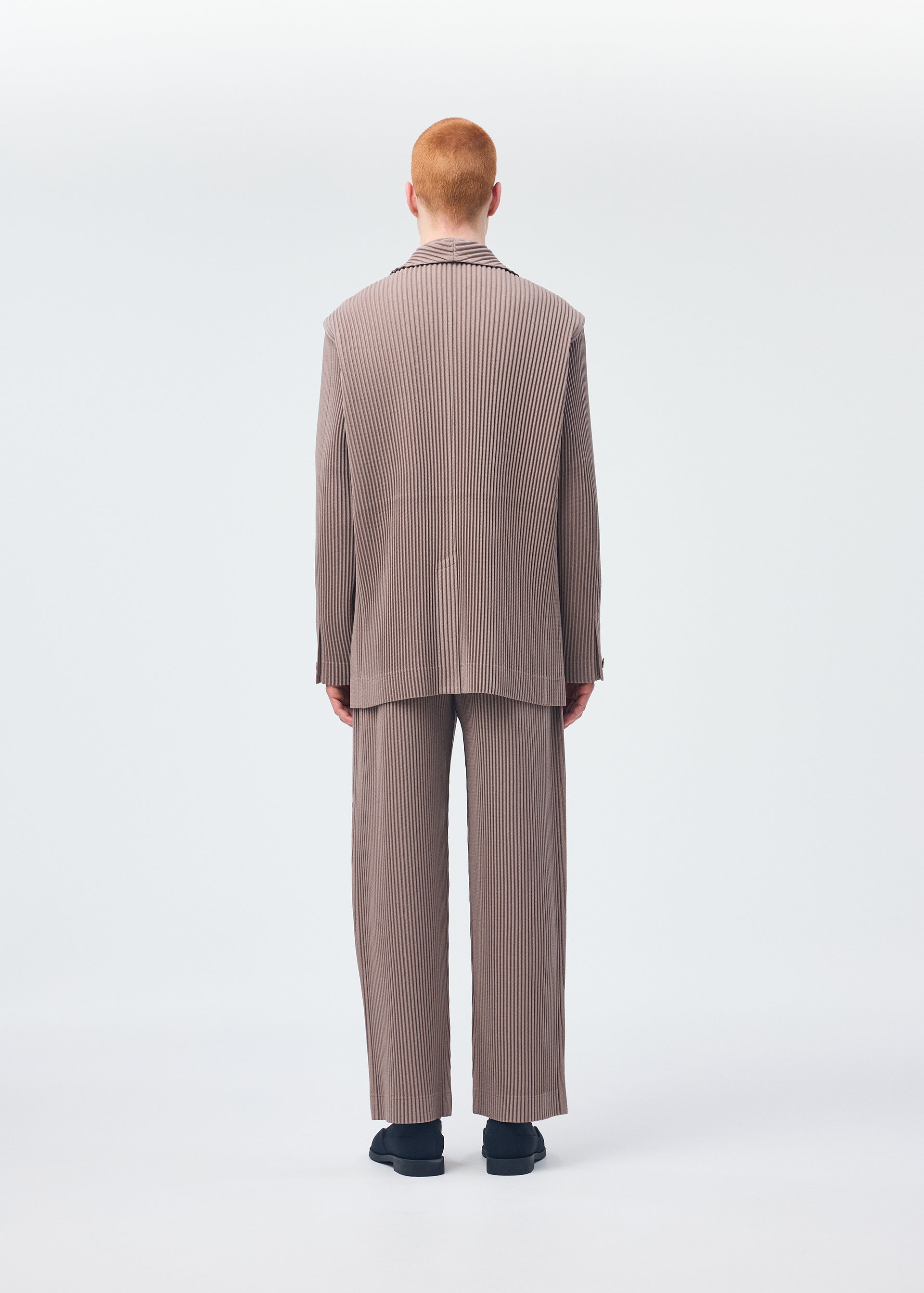 A model wears the HOMME PLISSÉ ISSEY MIYAKE KERSEY PLEATS jacket.