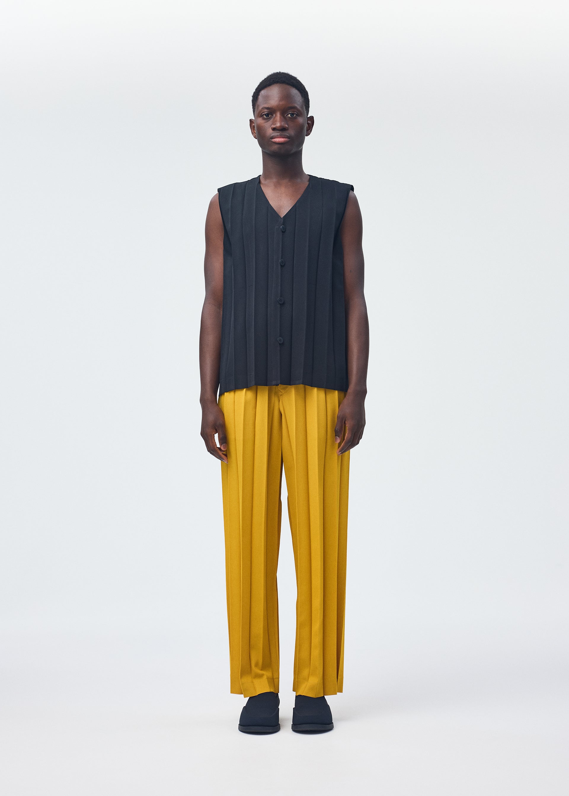 A model wears the HOMME PLISSÉ ISSEY MIYAKE EDGE ENSEMBLE trousers.