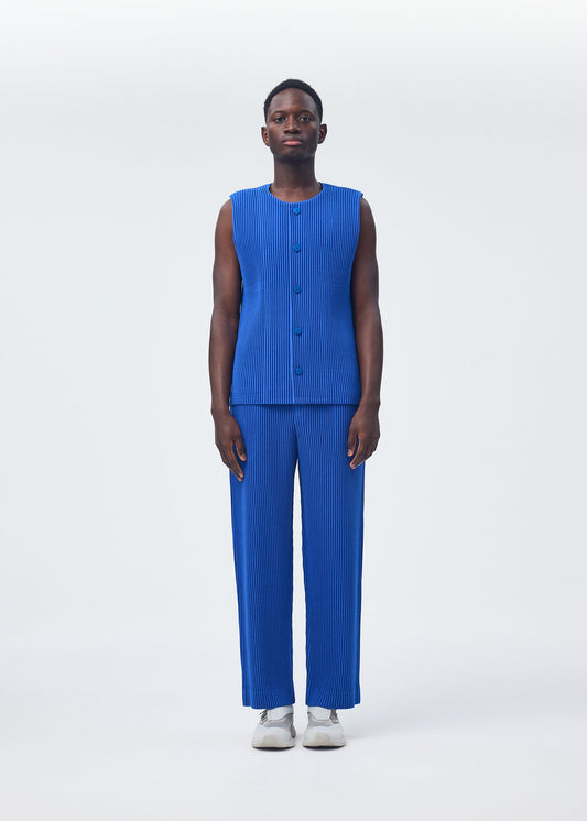 A model wears the HOMME PLISSÉ ISSEY MIYAKE KERSEY PLEATS trousers.