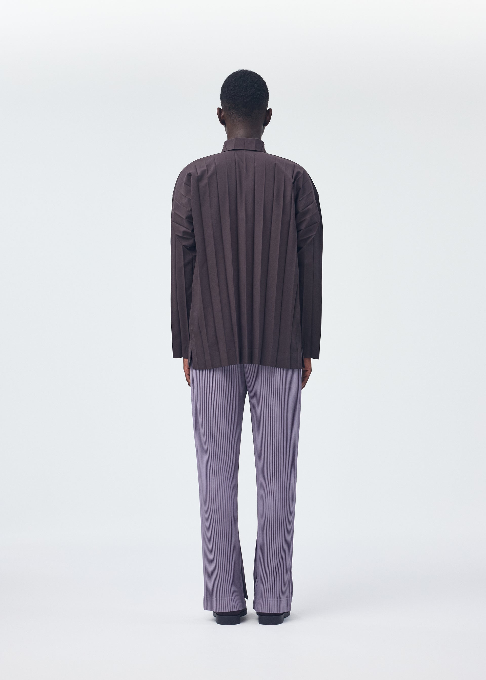A model wears the HOMME PLISSÉ ISSEY MIYAKE EDGE SHIRT shirt.