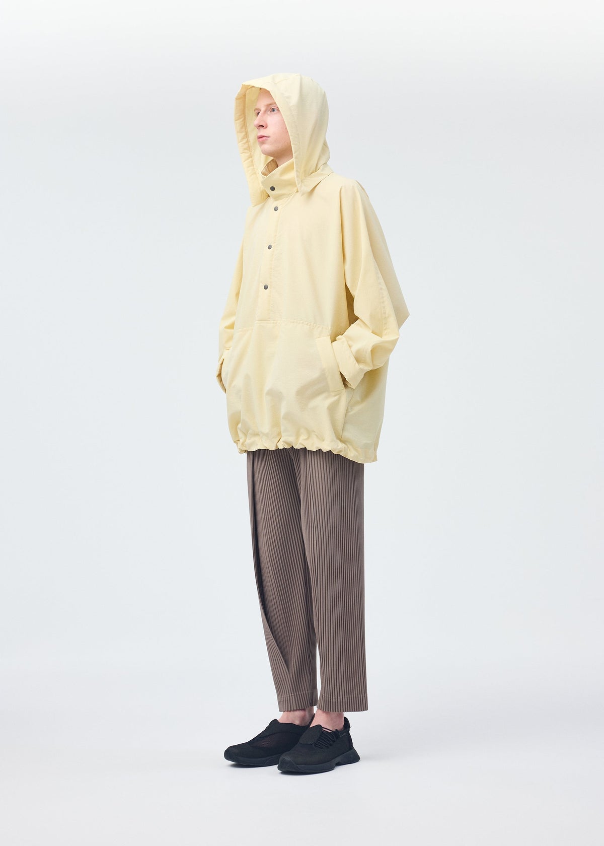 A model wears the HOMME PLISSÉ ISSEY MIYAKE PADDED RIM SHIRT shirt.