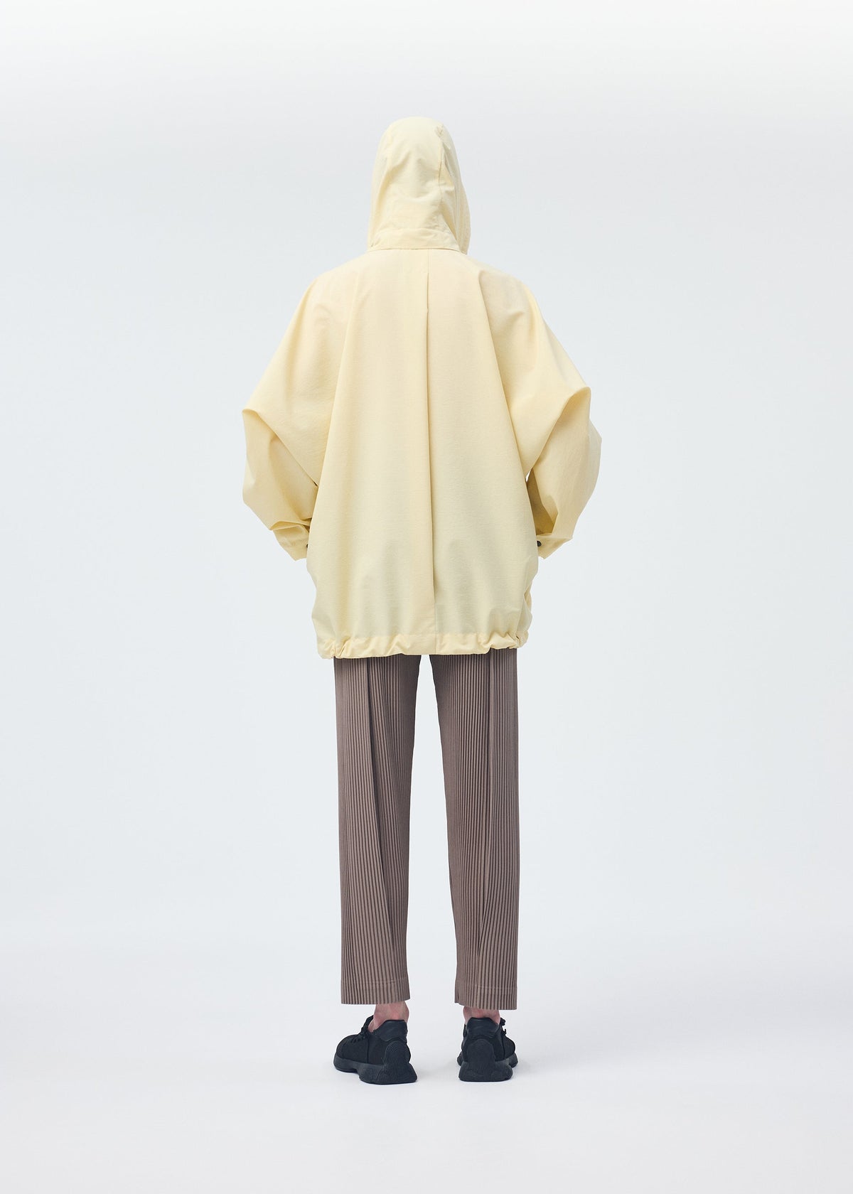 A model wears the HOMME PLISSÉ ISSEY MIYAKE PADDED RIM SHIRT shirt.