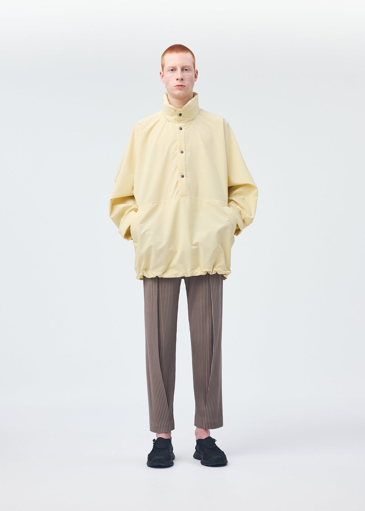 A model wears the HOMME PLISSÉ ISSEY MIYAKE PADDED RIM SHIRT shirt.