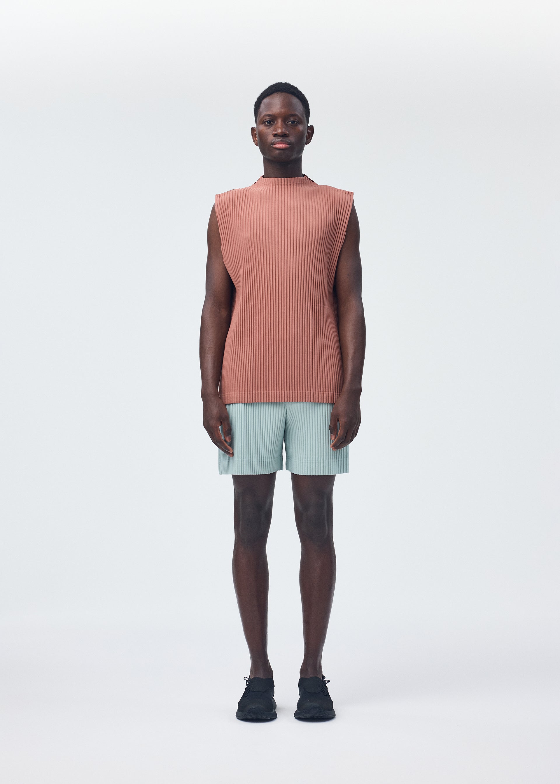 A model wears the HOMME PLISSÉ ISSEY MIYAKE MONTHLY COLORS JULY trousers.