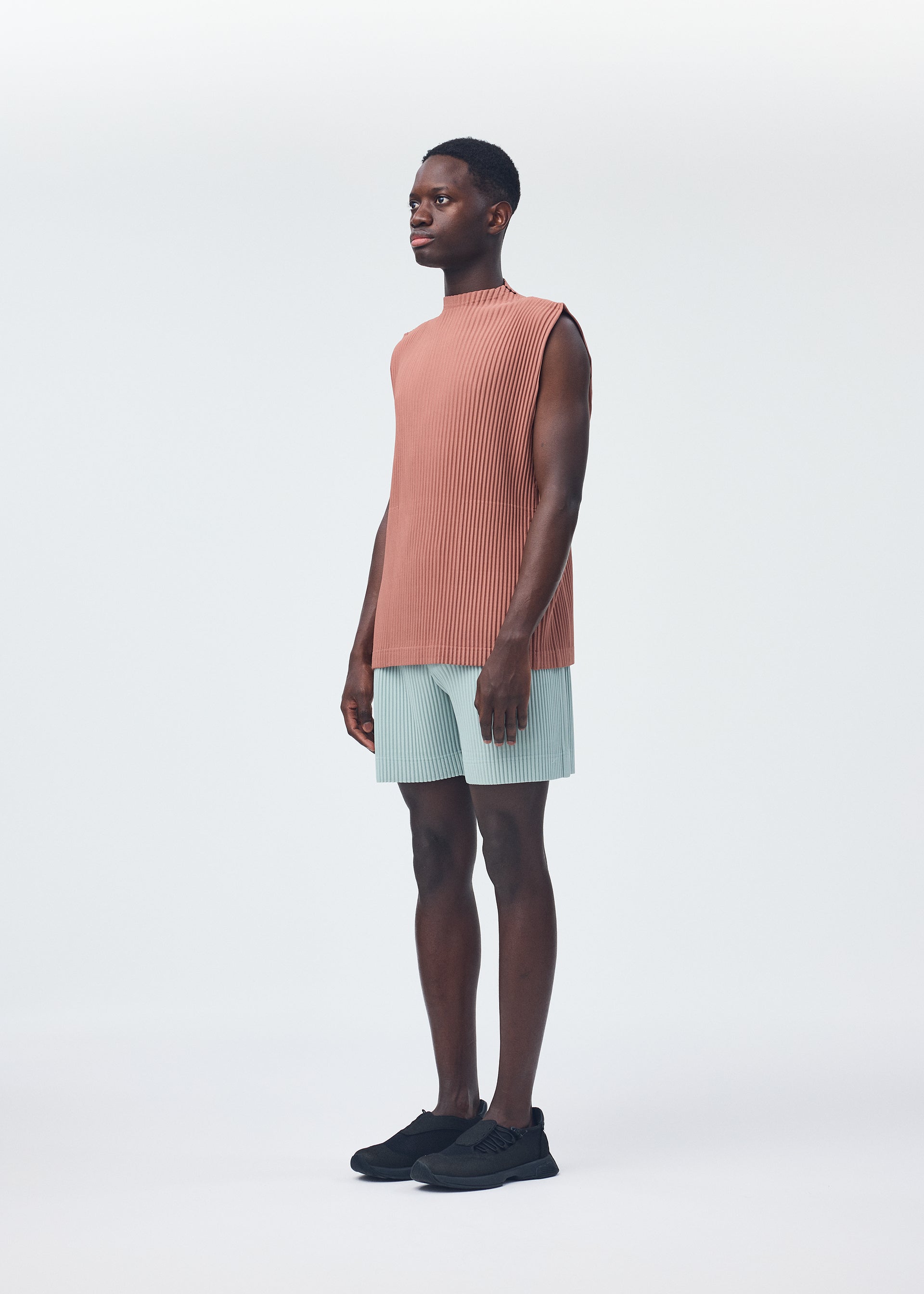 A model wears the HOMME PLISSÉ ISSEY MIYAKE MONTHLY COLORS JULY trousers.