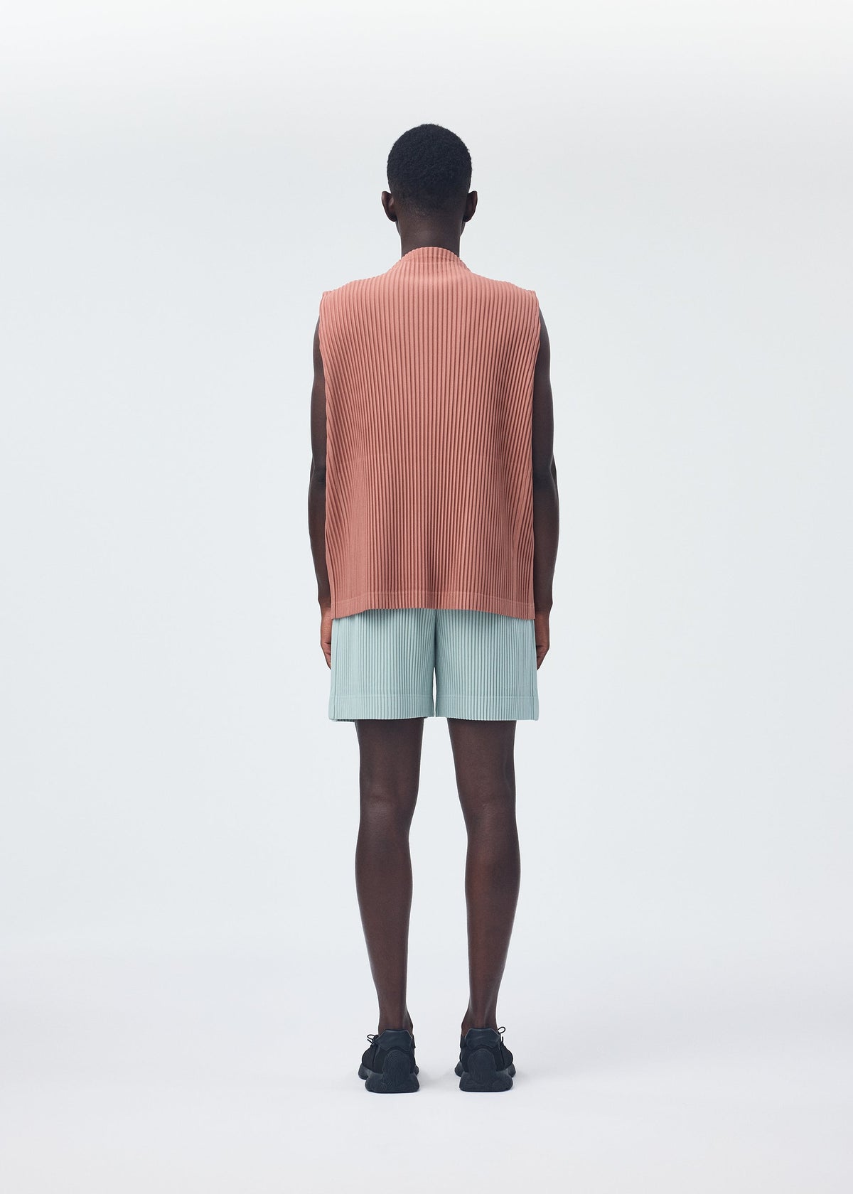 A model wears the HOMME PLISSÉ ISSEY MIYAKE MONTHLY COLORS JULY trousers.