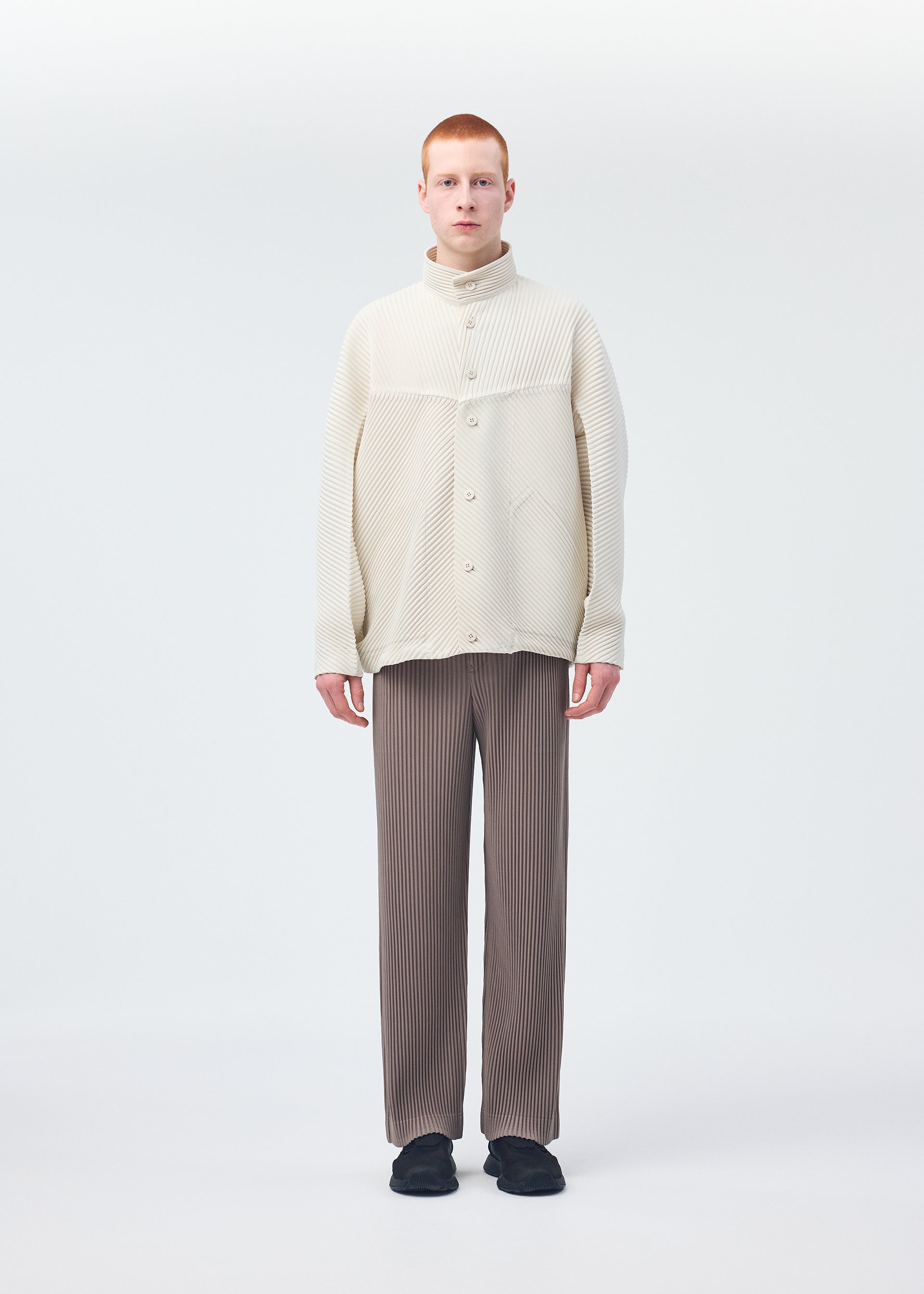 A model wears the HOMME PLISSÉ ISSEY MIYAKE MONTHLY COLORS SEPTEMBER trousers.