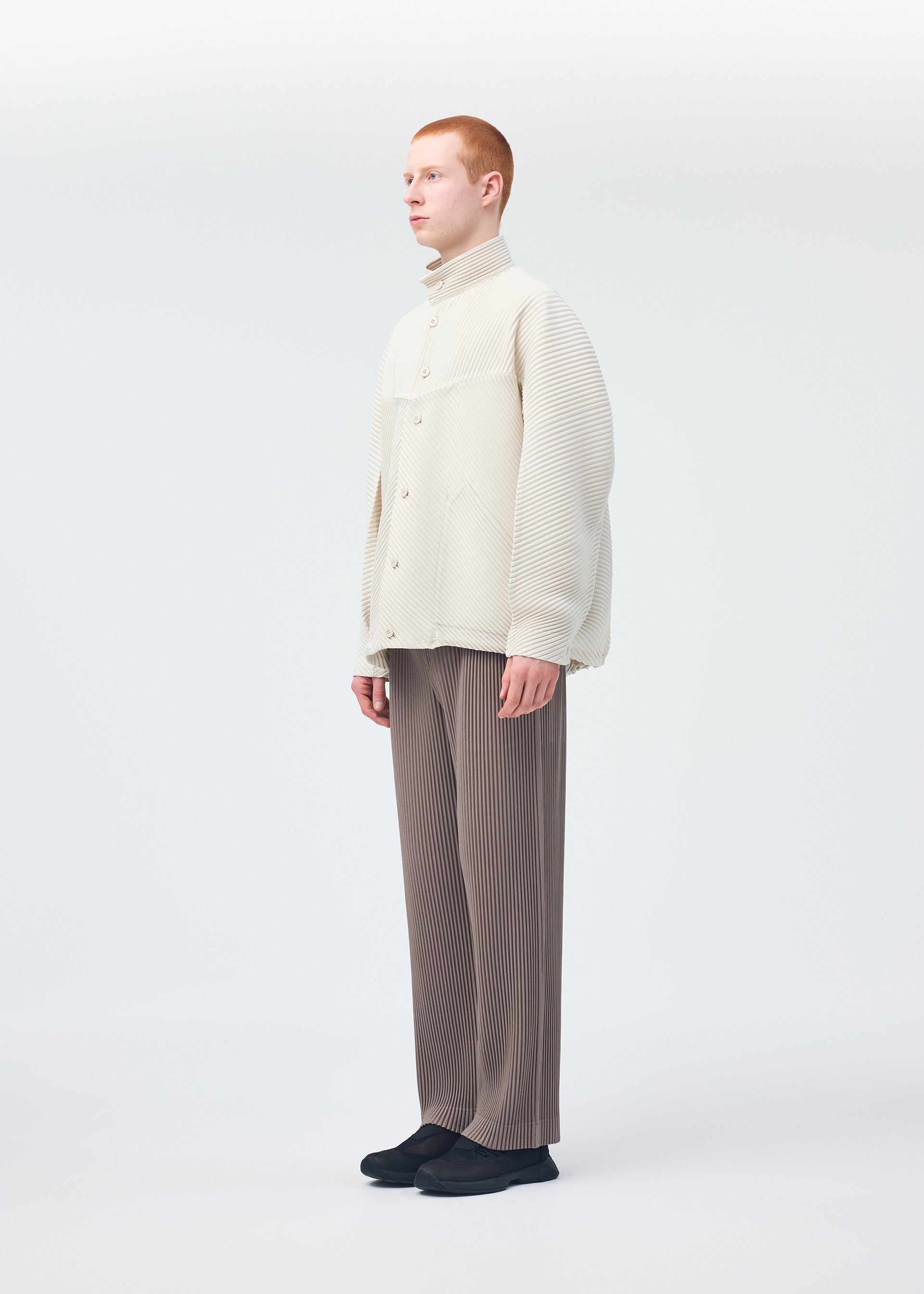 A model wears the HOMME PLISSÉ ISSEY MIYAKE MONTHLY COLORS SEPTEMBER trousers.