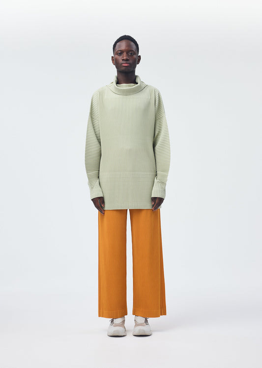 A model wears the HOMME PLISSÉ ISSEY MIYAKE MONTHLY COLORS OCTOBER trousers.