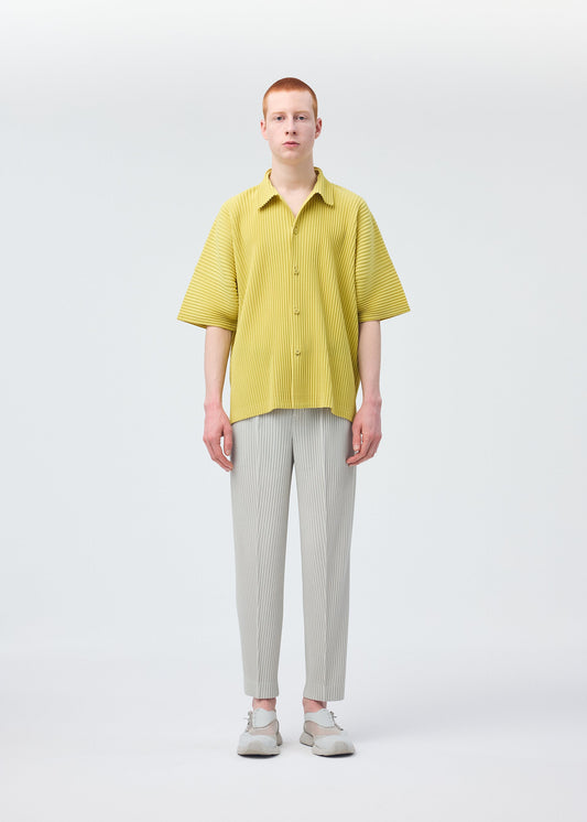 A model wears the HOMME PLISSÉ ISSEY MIYAKE COMPLEAT TROUSERS trousers.