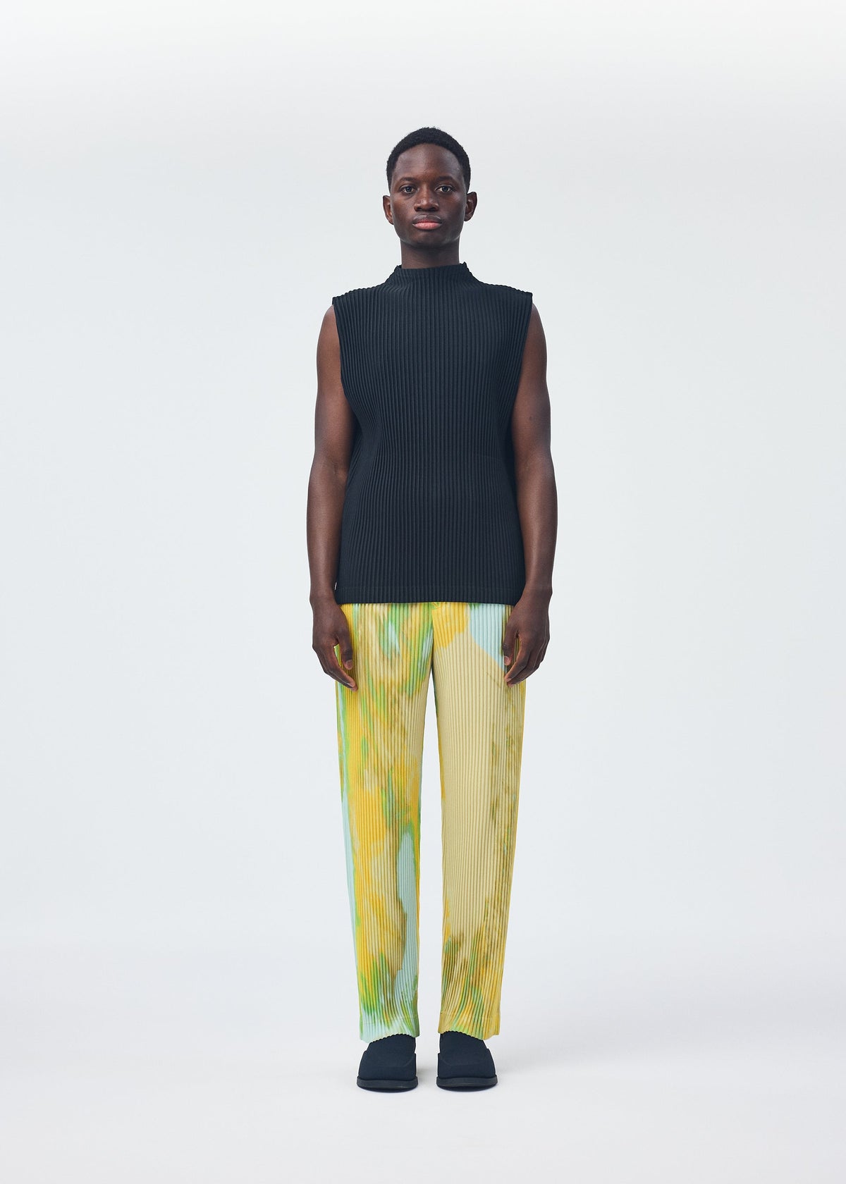 A model wears the HOMME PLISSÉ ISSEY MIYAKE AGATE trousers.