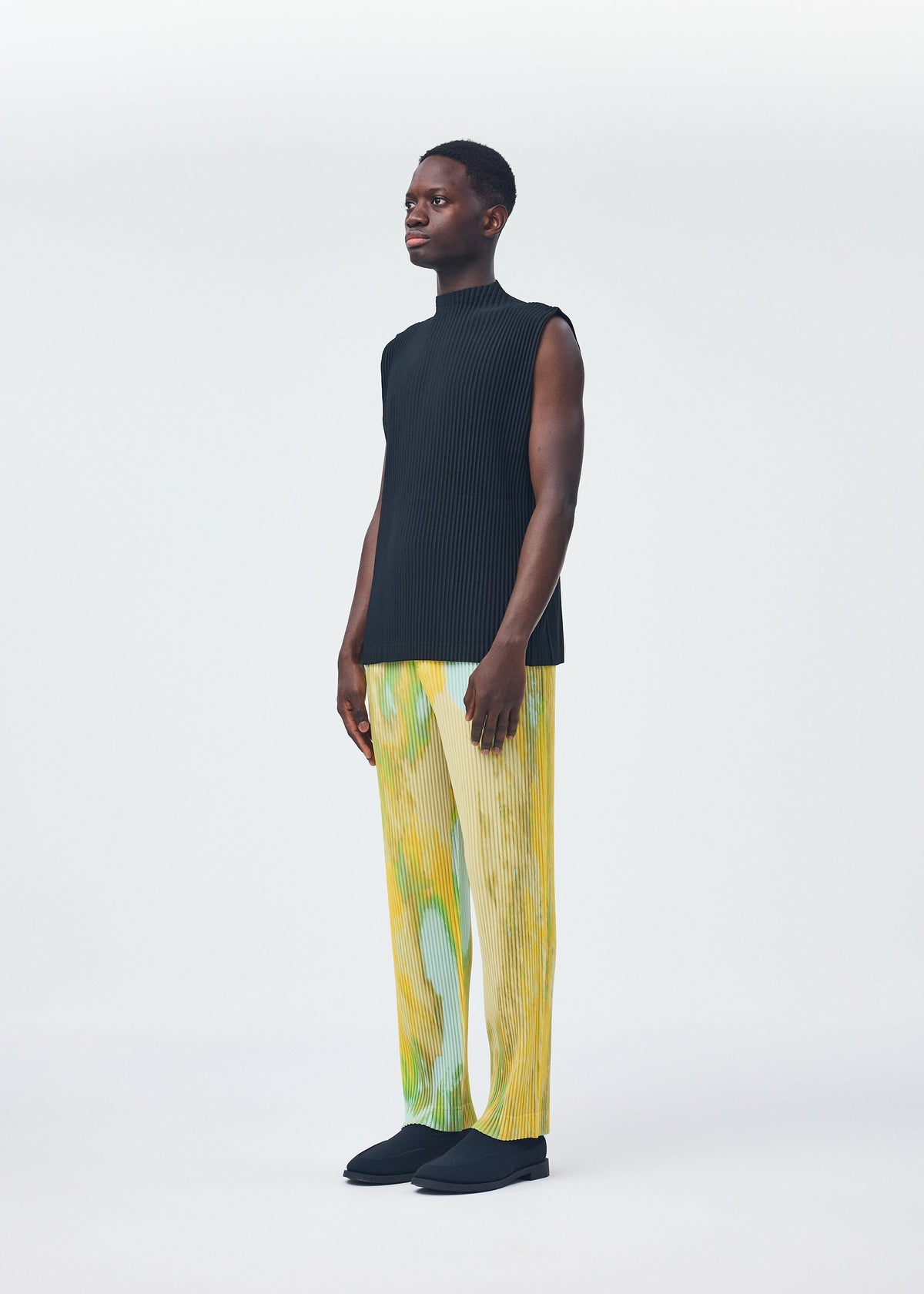 A model wears the HOMME PLISSÉ ISSEY MIYAKE AGATE trousers.