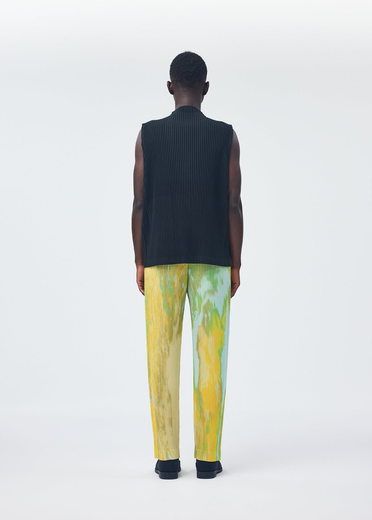 A model wears the HOMME PLISSÉ ISSEY MIYAKE AGATE trousers.