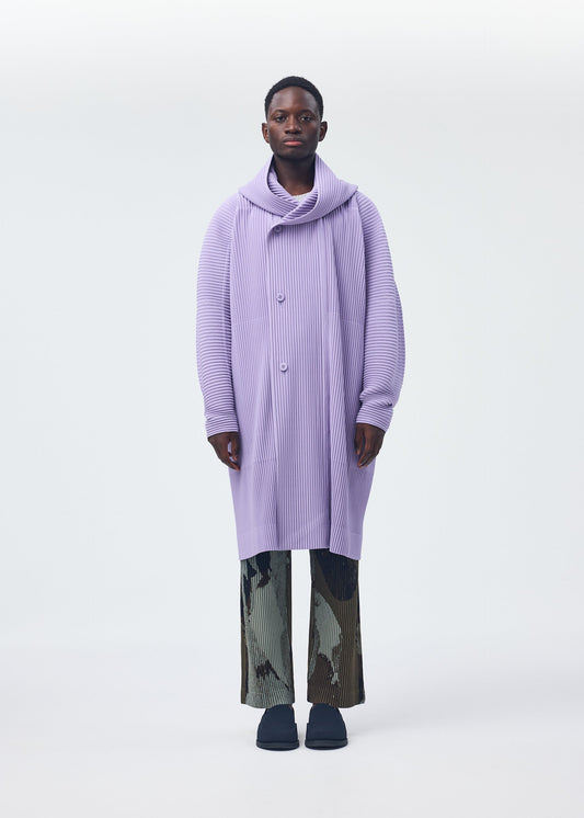 A model wears the HOMME PLISSÉ ISSEY MIYAKE PAINTED STONE clothing.