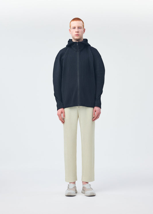 A model wears the HOMME PLISSÉ ISSEY MIYAKE WICKERWORK MESH trousers.