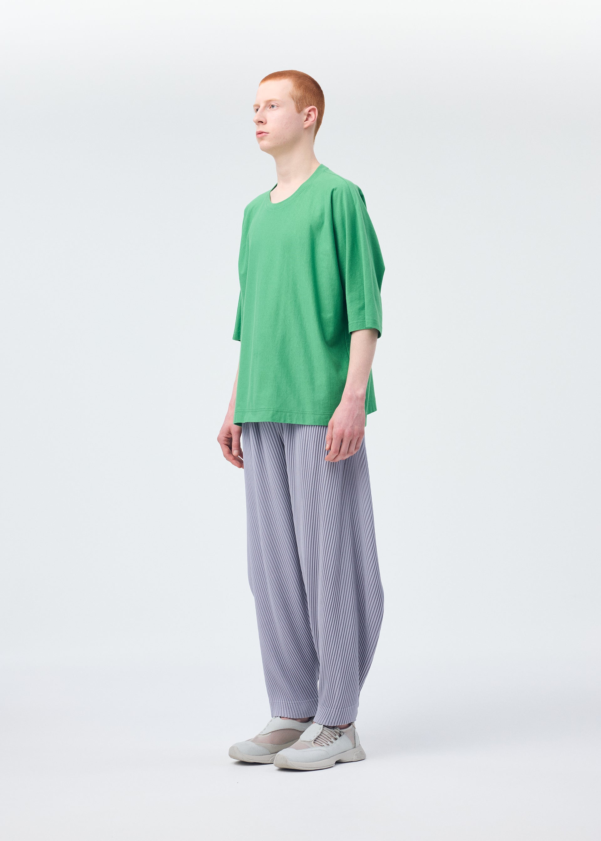 A model wears the HOMME PLISSÉ ISSEY MIYAKE ANGULAR STONE trousers.
