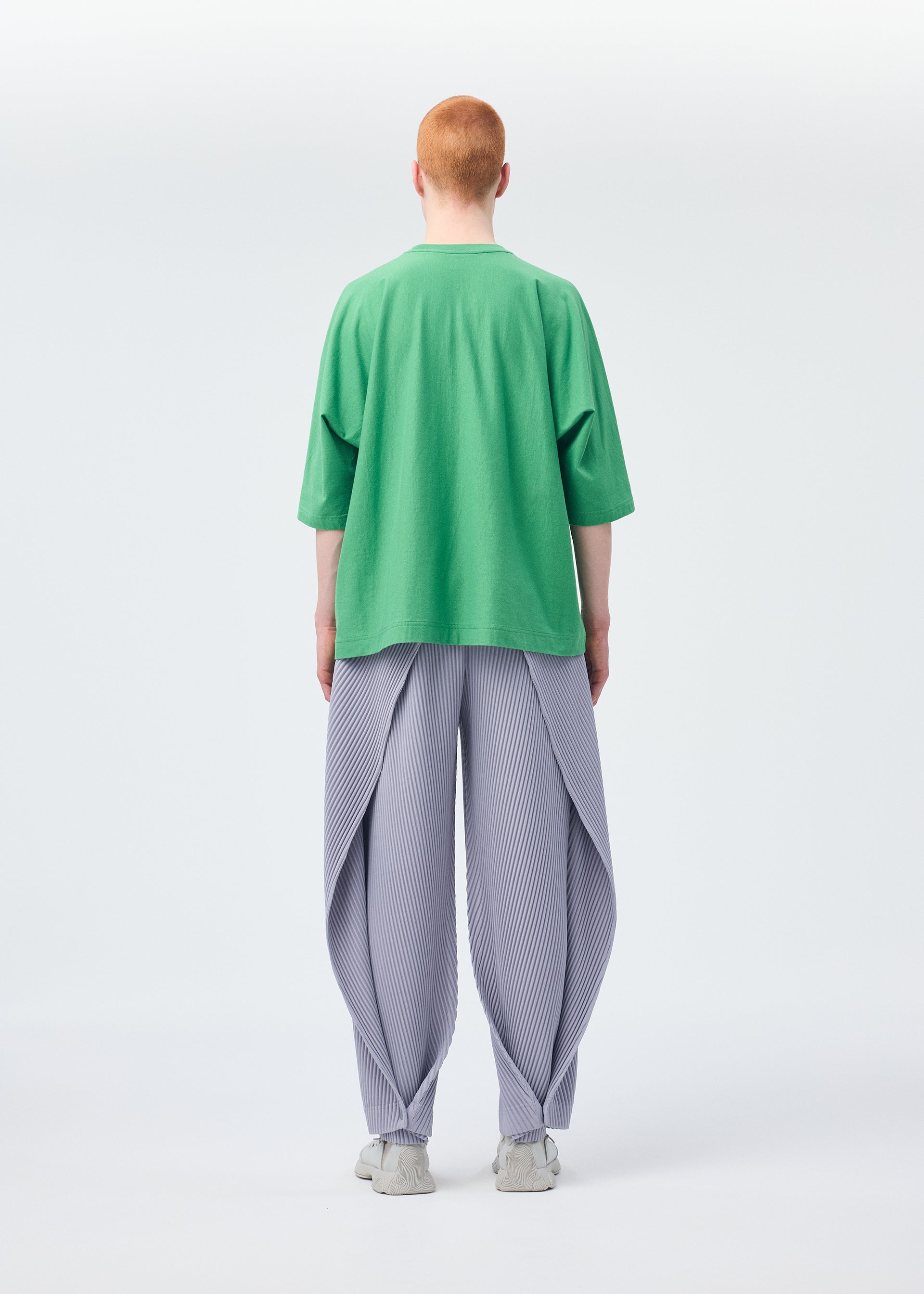 A model wears the HOMME PLISSÉ ISSEY MIYAKE ANGULAR STONE trousers.