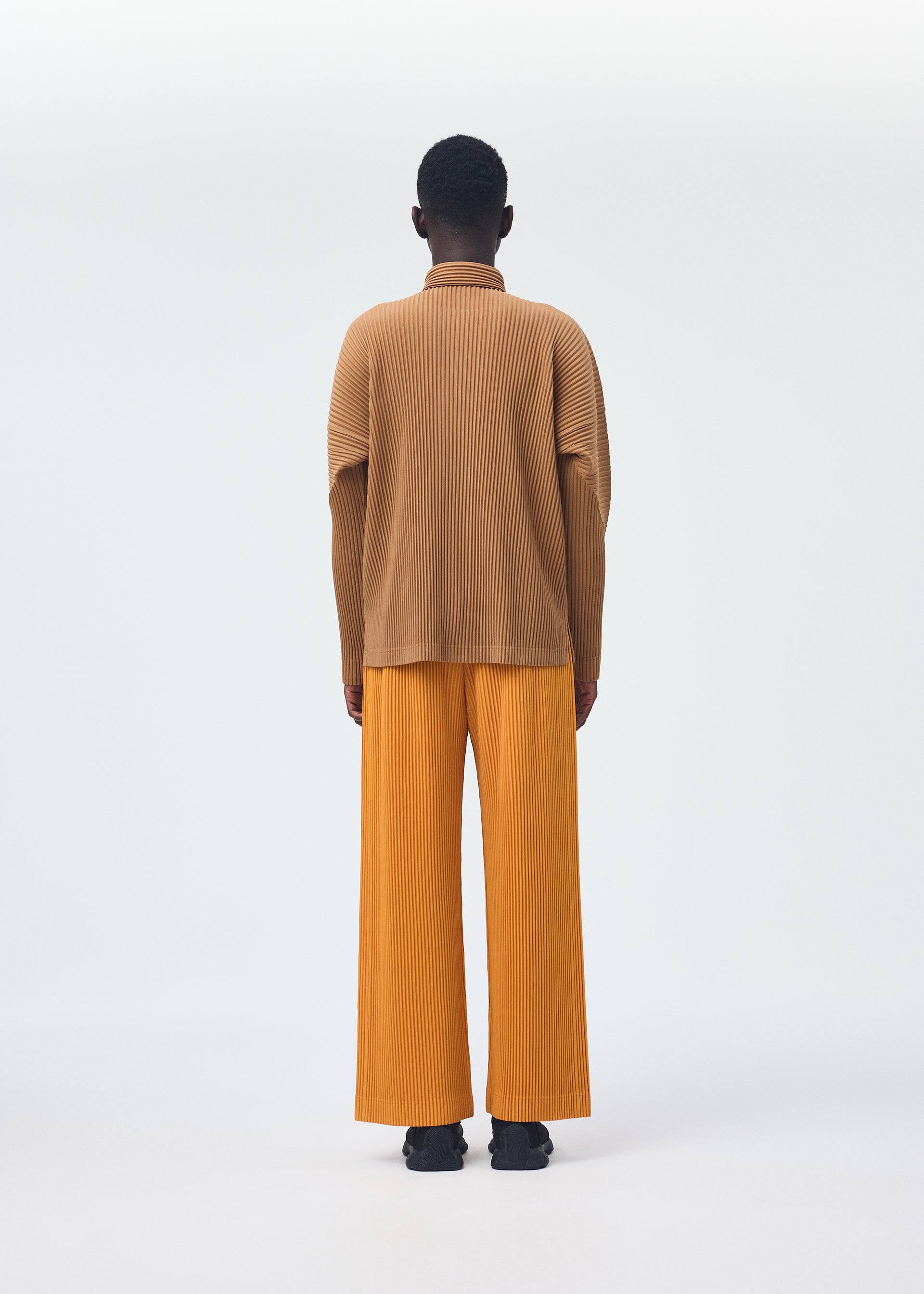 A model wears the HOMME PLISSÉ ISSEY MIYAKE MONTHLY COLORS OCTOBER shirt.