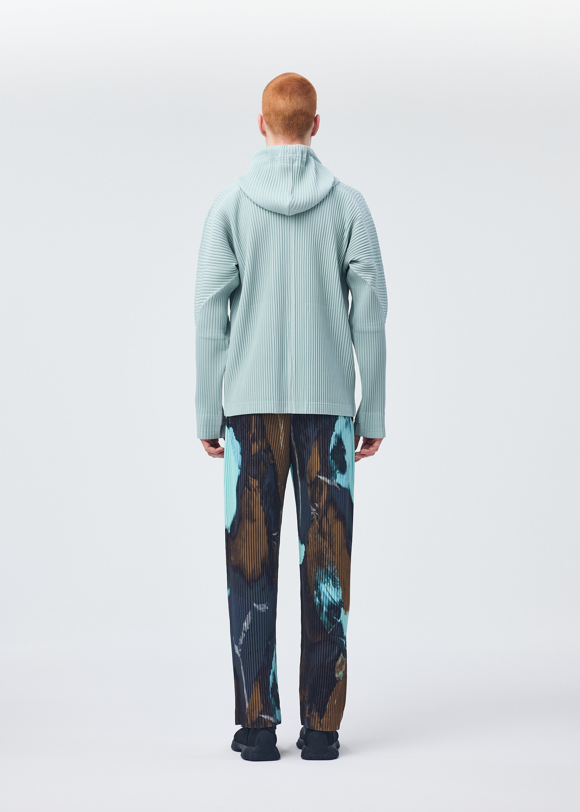 A model wears the HOMME PLISSÉ ISSEY MIYAKE MONTHLY COLORS JULY shirt.