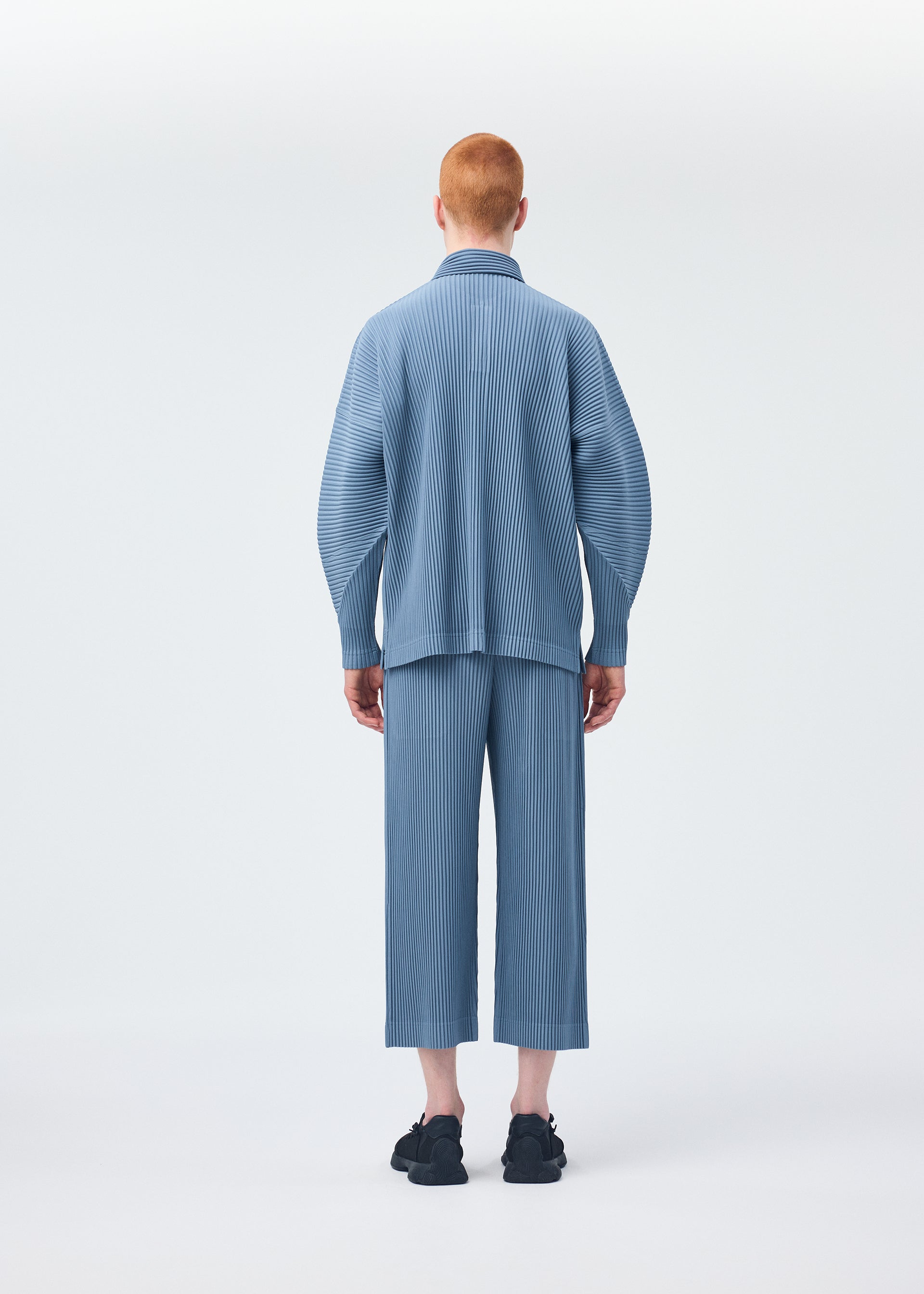 A model wears the HOMME PLISSÉ ISSEY MIYAKE MONTHLY COLORS AUGUST shirt.