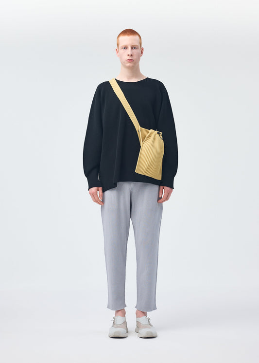 A model wears the HOMME PLISSÉ ISSEY MIYAKE BASIC KNIT top.