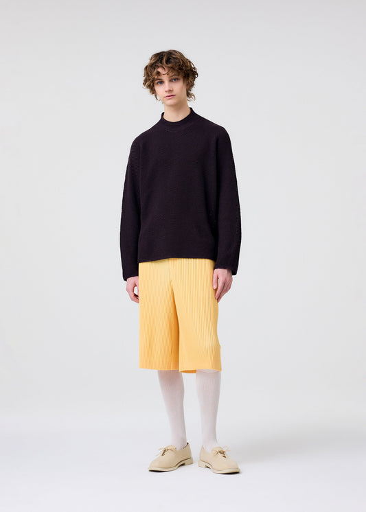 A model wears the HOMME PLISSÉ ISSEY MIYAKE RUSTIC KNIT top.