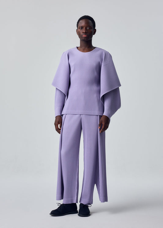 A model wears the HOMME PLISSÉ ISSEY MIYAKE MOTION BLUR top.