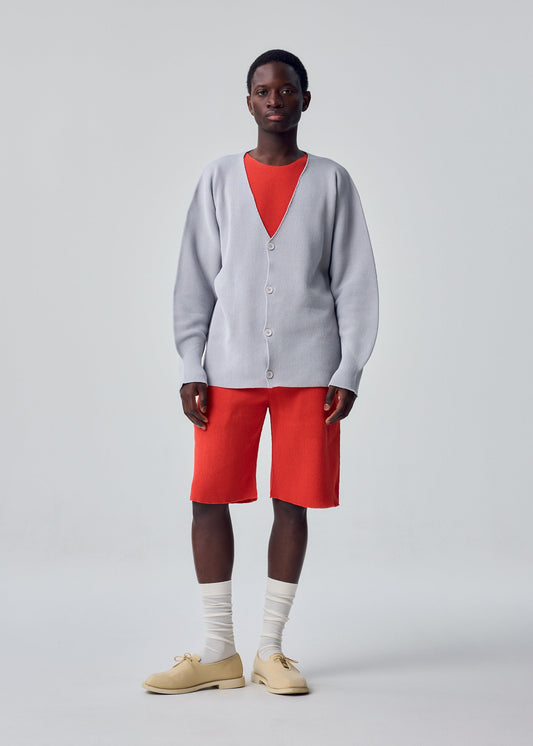 A model wears the HOMME PLISSÉ ISSEY MIYAKE BASIC KNIT basic-knit-button-front-cardigan-black.