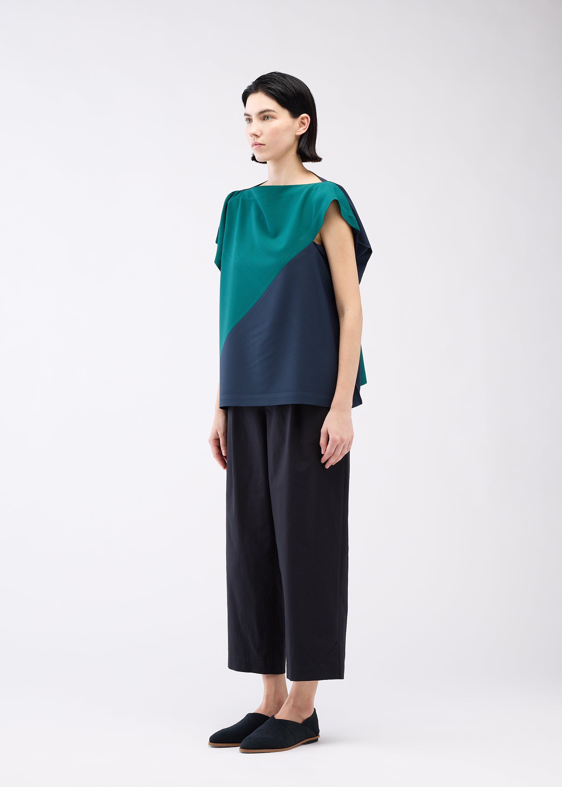 A model wears the 132 5. ISSEY MIYAKE FLAT T BI COLOR shirt.