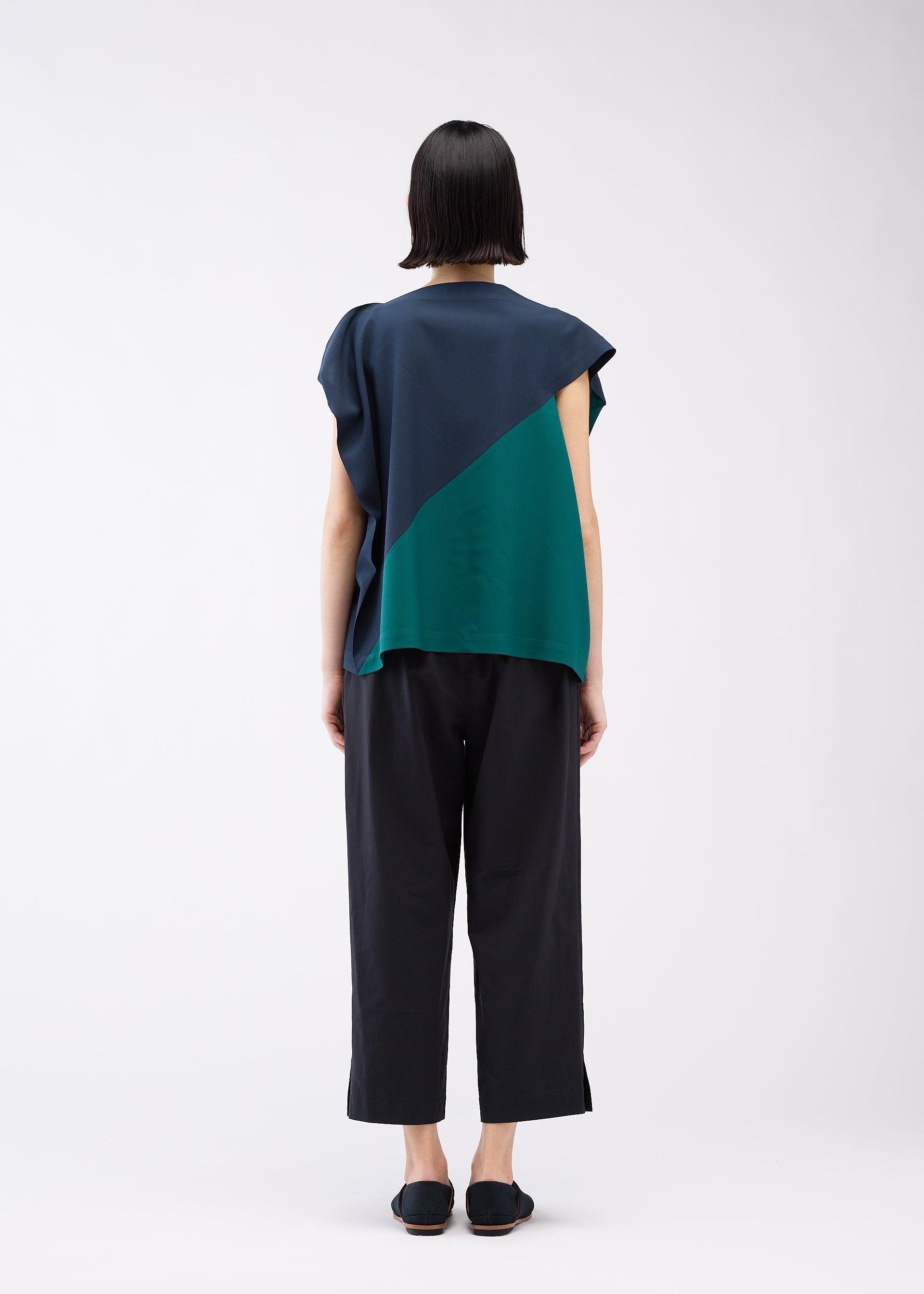 A model wears the 132 5. ISSEY MIYAKE FLAT T BI COLOR shirt.