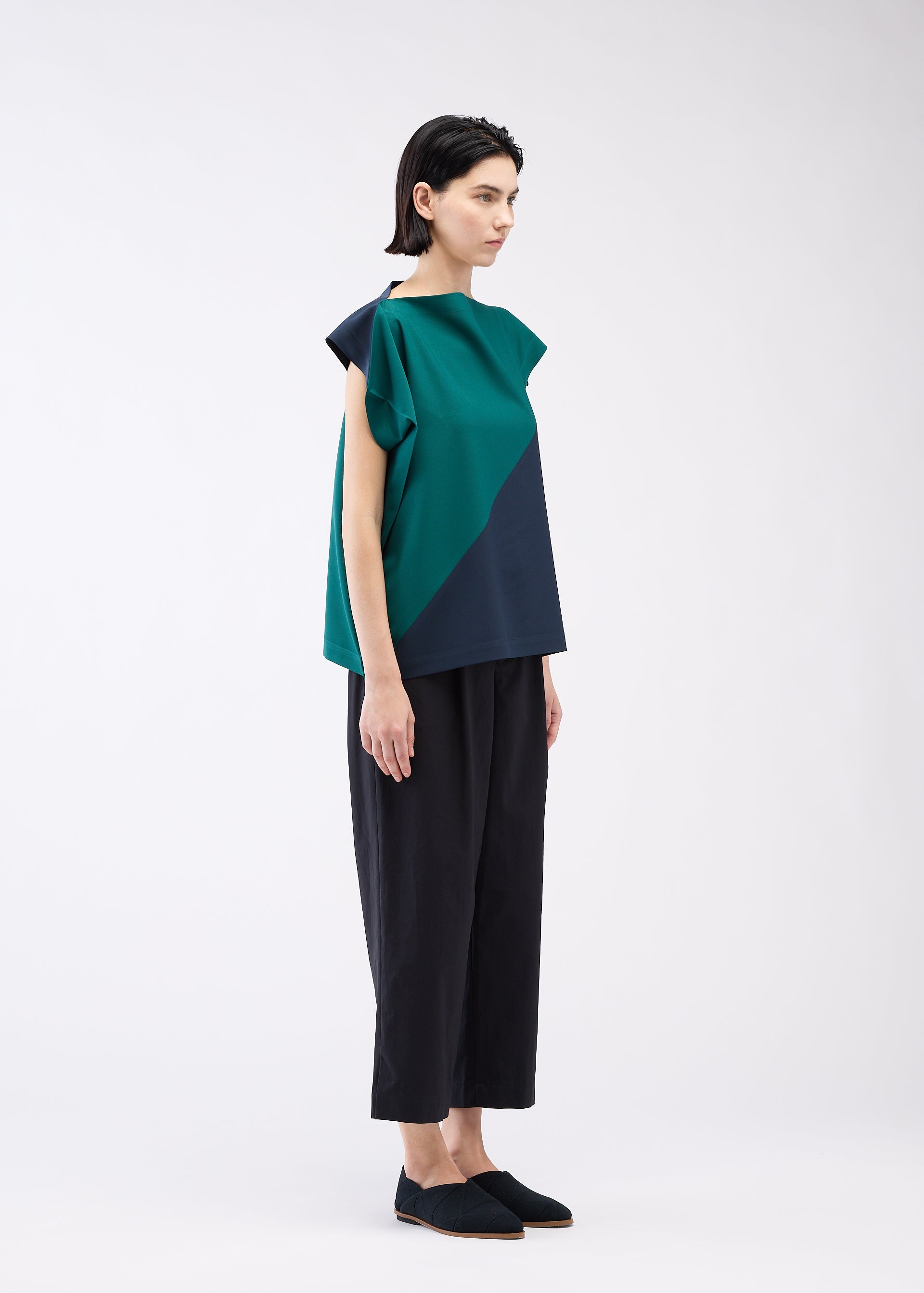 A model wears the 132 5. ISSEY MIYAKE FLAT T BI COLOR shirt.