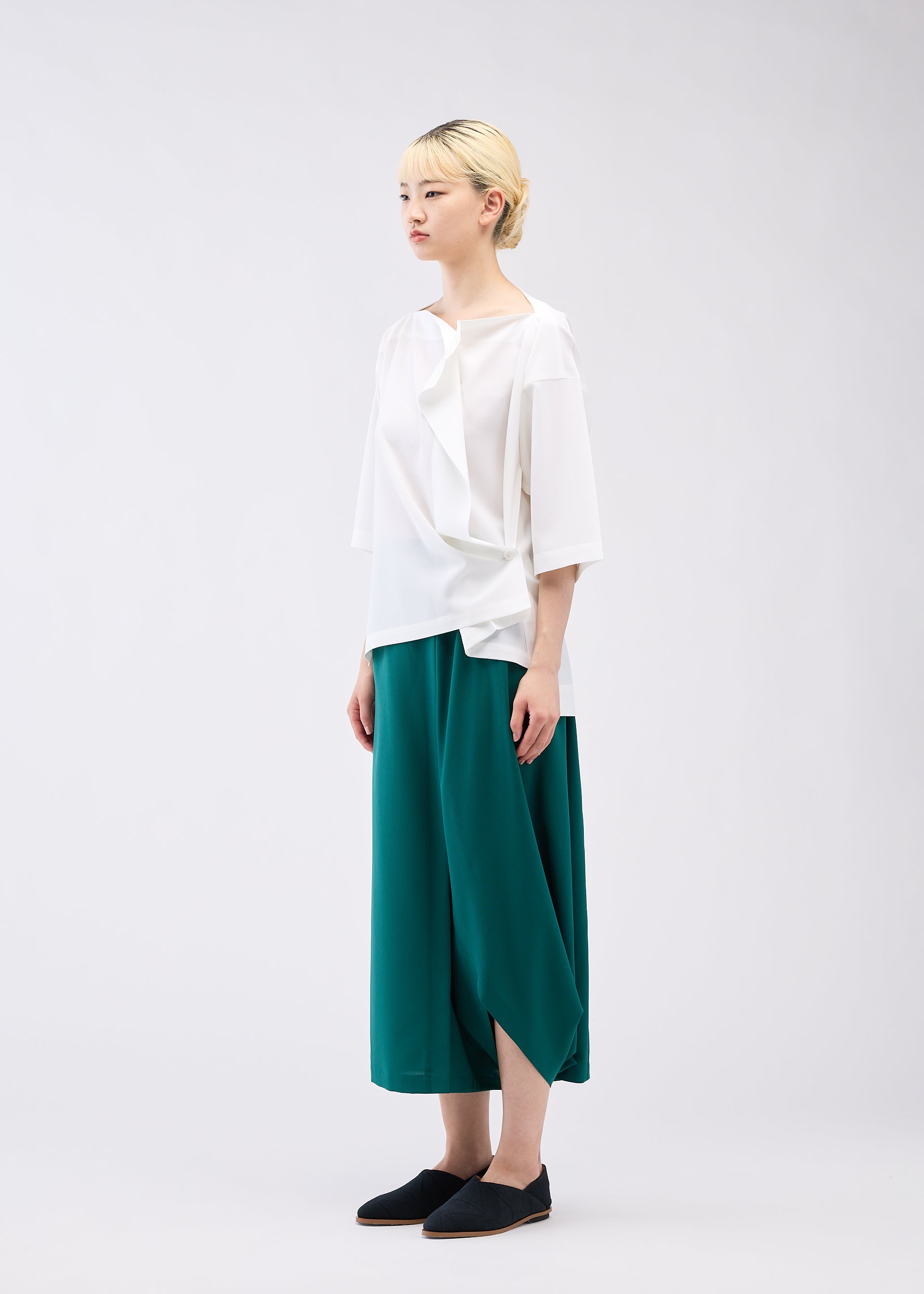 A model wears the 132 5. ISSEY MIYAKE FLAT ONE TUCK T shirt.