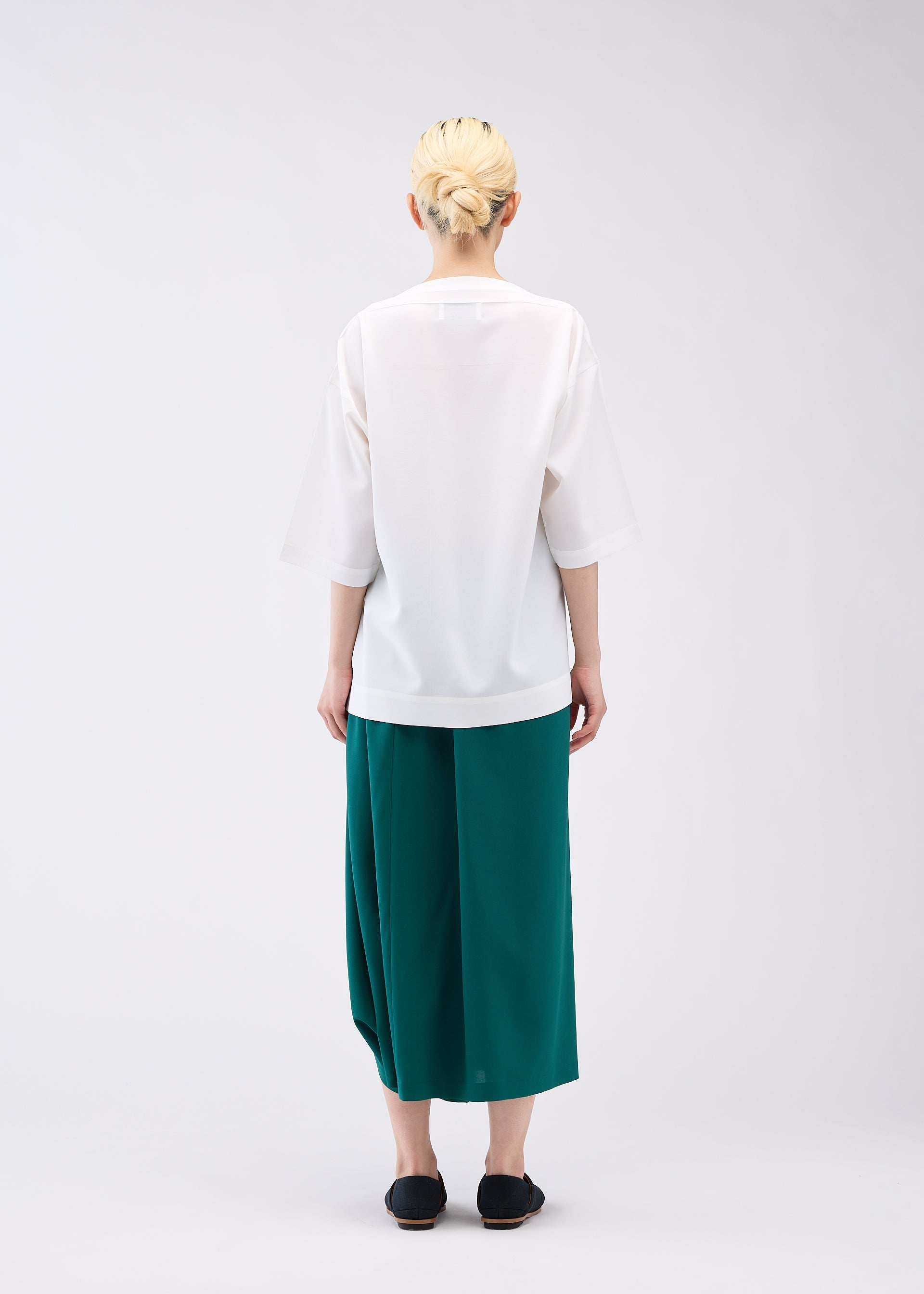 A model wears the 132 5. ISSEY MIYAKE FLAT ONE TUCK T shirt.